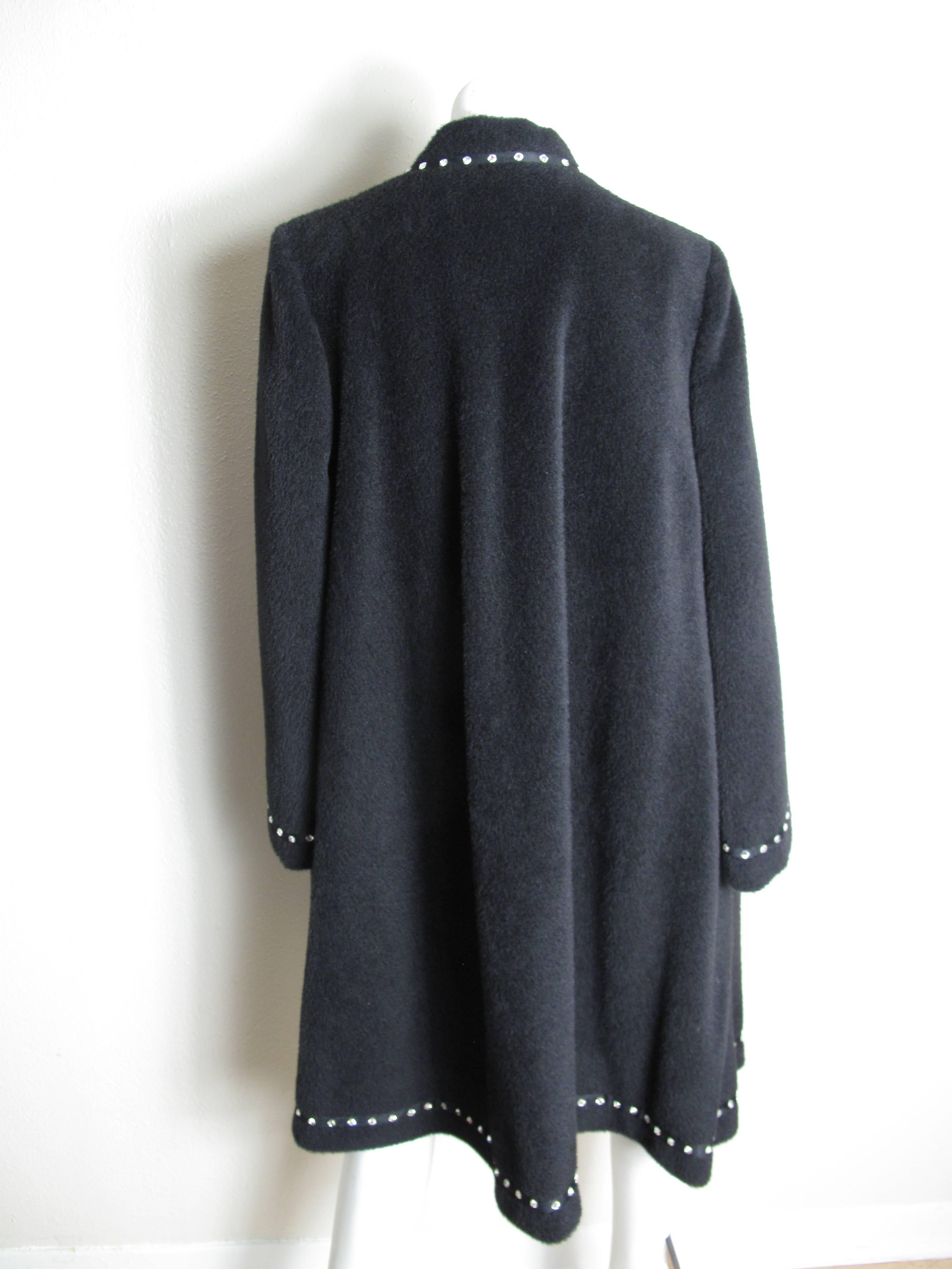 Pauline Trigere black wool coat with rhinestone trim.  Condition: Excellent. Size L
sleeve: 25", 17.5" shoulder.

We accept returns for refund, please see our terms.  We offer free ground shipping within the US.  Please let us know if