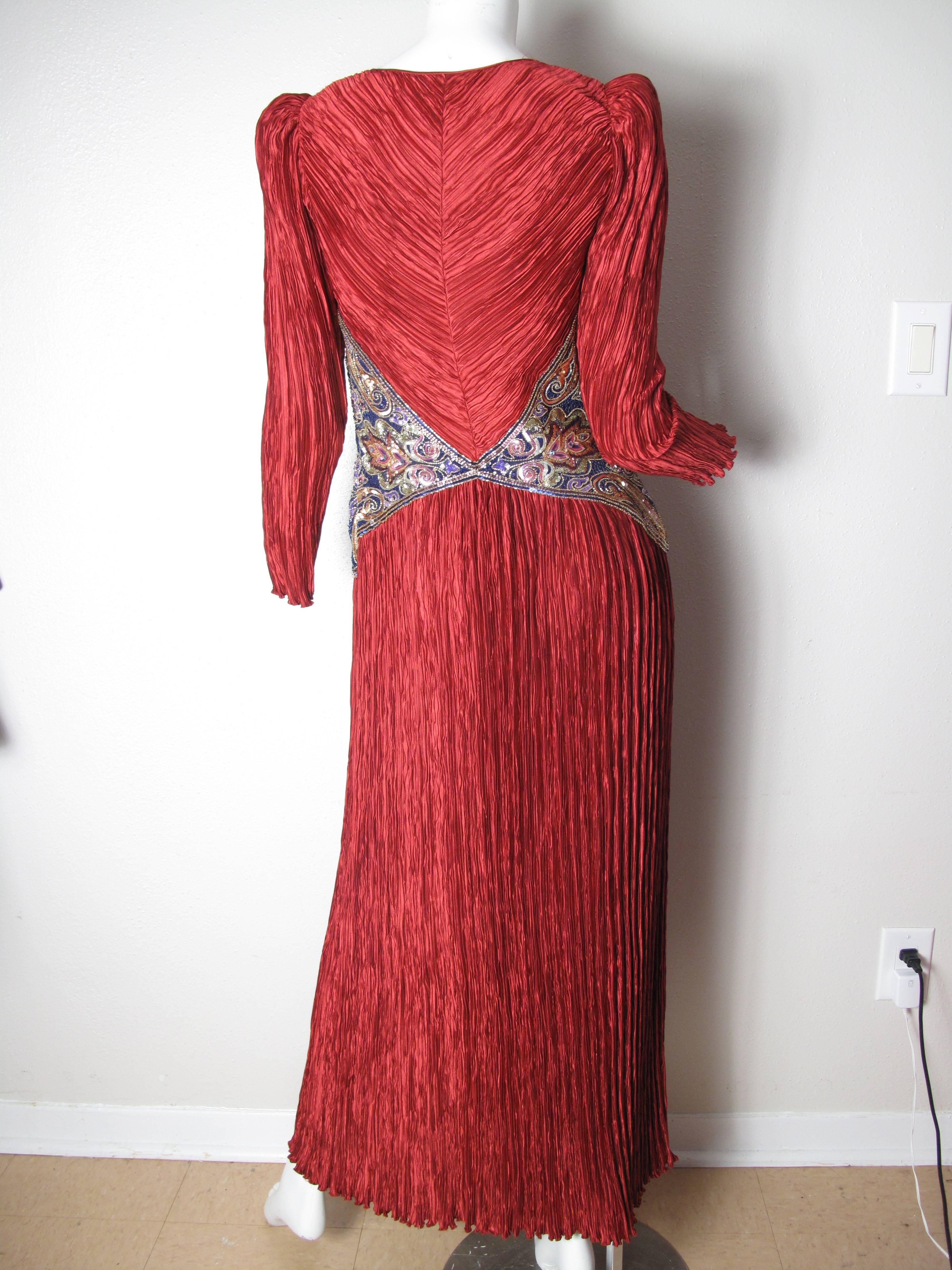 Mary McFadden red pleated gown with beaded and sequin around waist.  Condition: Excellent. Size 10, fits US 8 -10

We offer free ground shipping within the US.  We accept returns for refund, please see our terms.  Please let us know if you have any