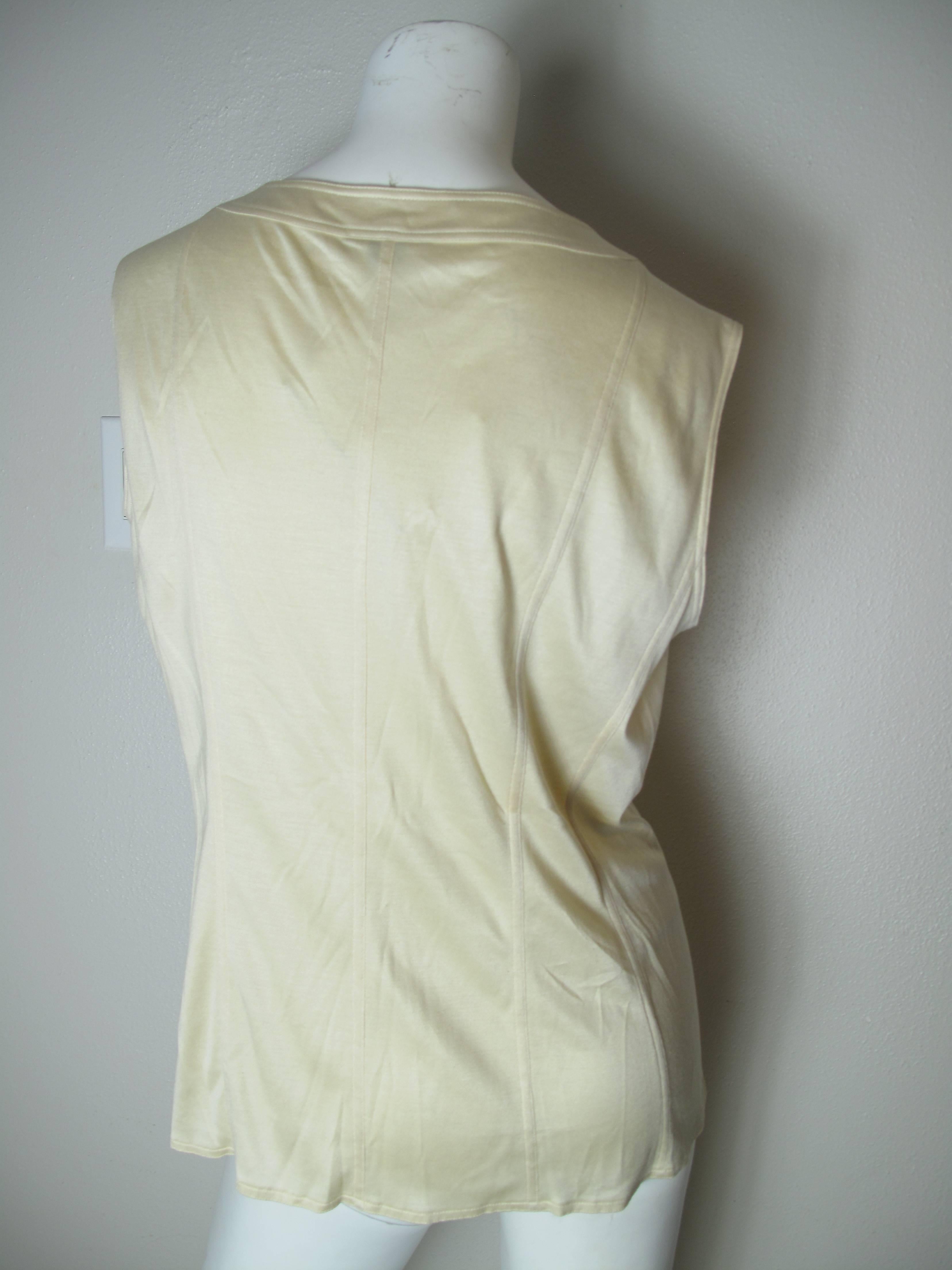 Chanel boutique sleeveless off white top with buttons down front.  Condition: Excellent, never worn.  Size 14/ EU 44

We accept returns for refund, please see our terms.  We offer free ground shipping within the US. Please let us know if you have