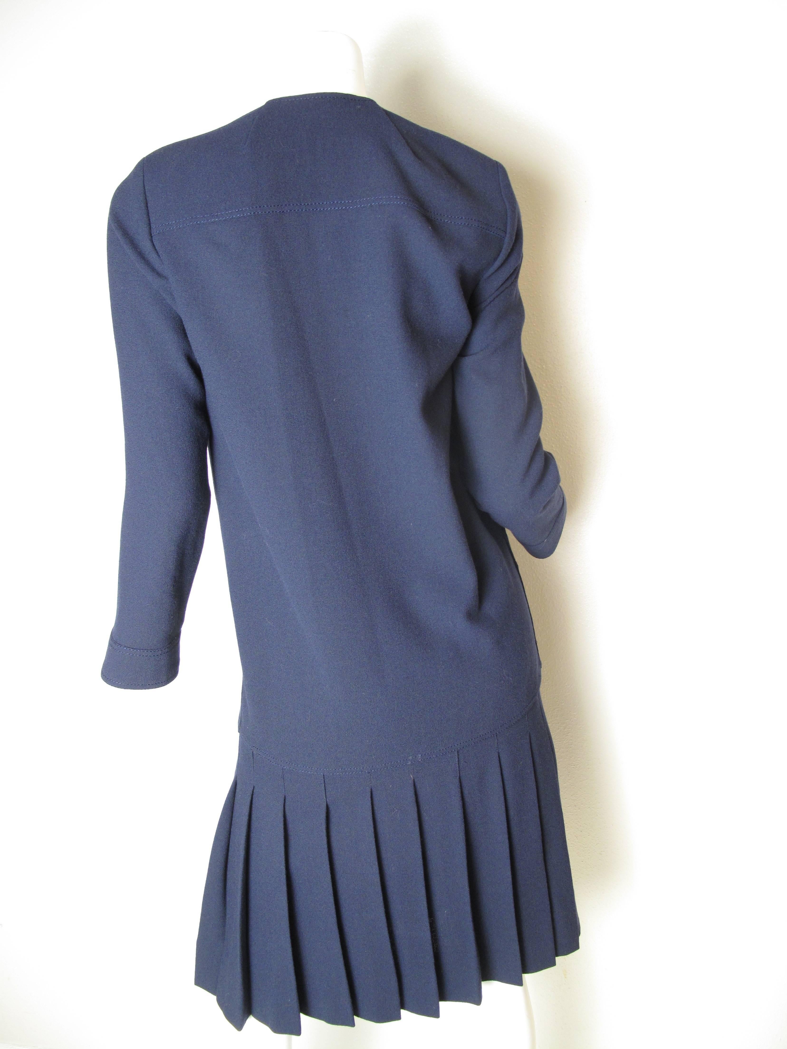 Chanel navy wool suit with pleated skirt. Double breasted jacket.  Condition: Excellent. Size 6

 We accept returns for refund, please see our terms. We offer free ground shipping within the US. Please let us know if you have any questions.