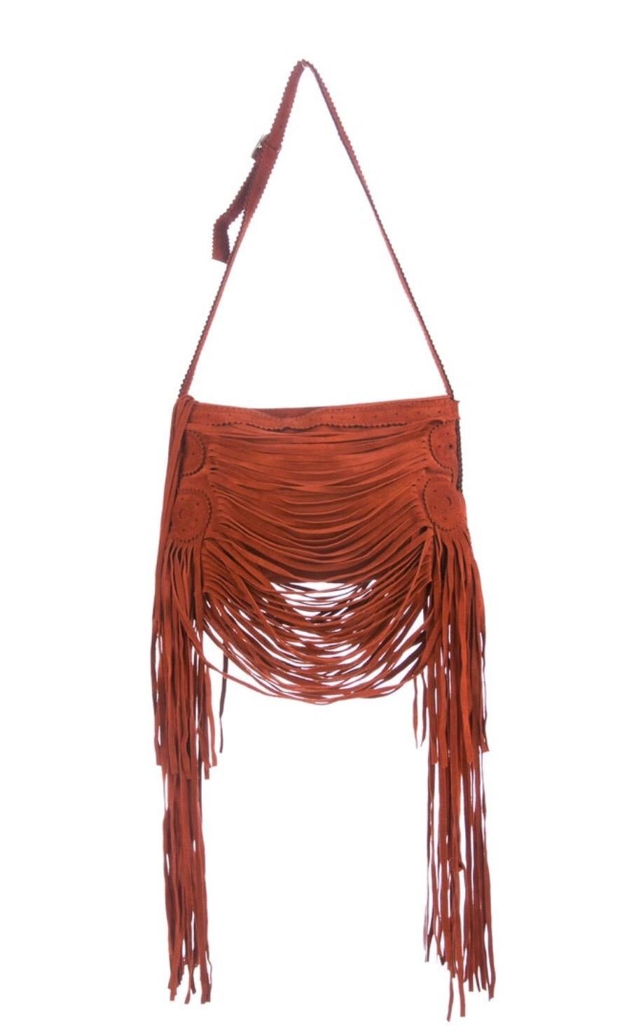 Rust suede Jean Paul Gaultier shoulder bag. Fringe accents throughout exterior, black satin lining and zip closure at top. Condition: Excellent.  7