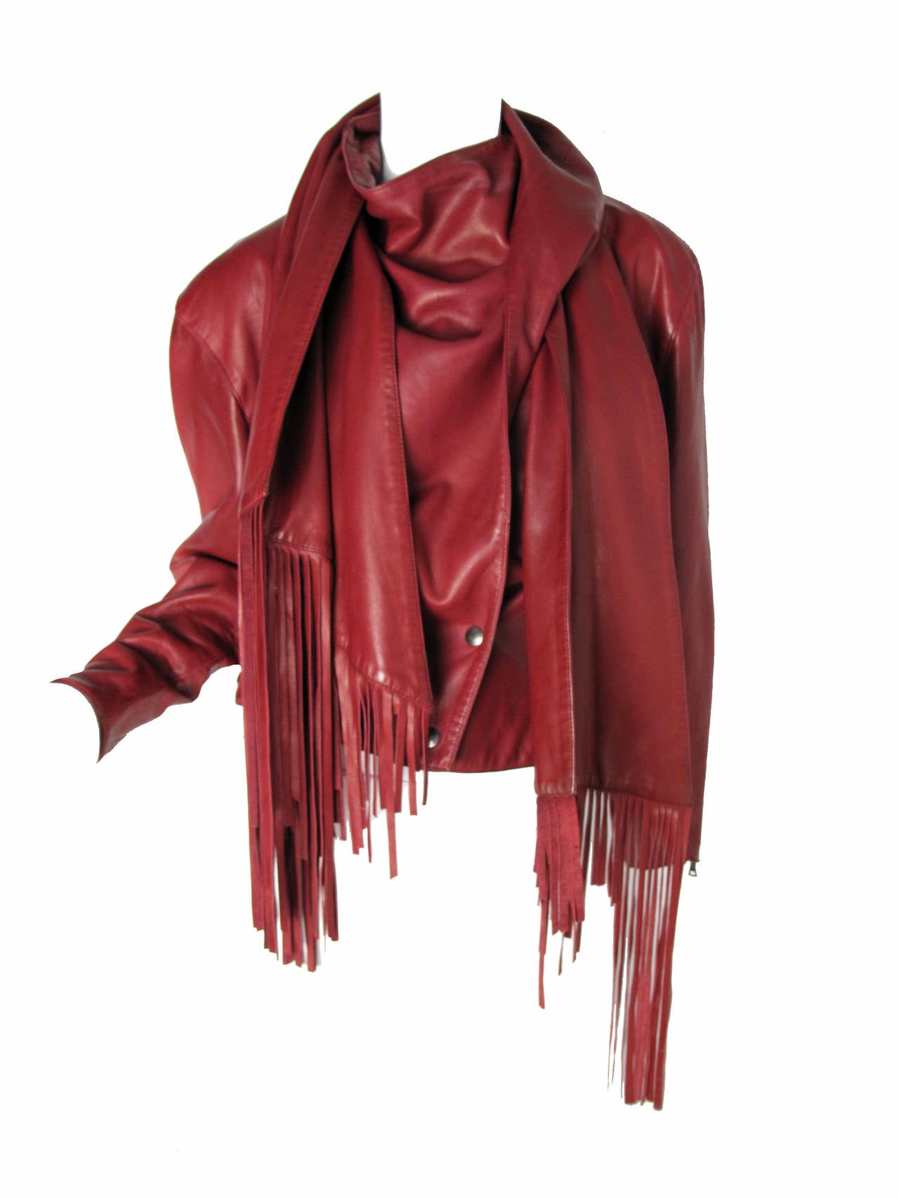 1980s Claude Montana wine colored fringe leather jacket.  Super soft leather. Attached leather scarf wraps around with fringe.  Zippers on cuts. Two snaps to close. 
36