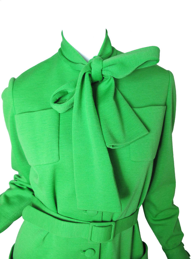 Norman Norell green wool dress. Four front pockets.  Condition: AS IS : Moth hole, spot on bow.  37