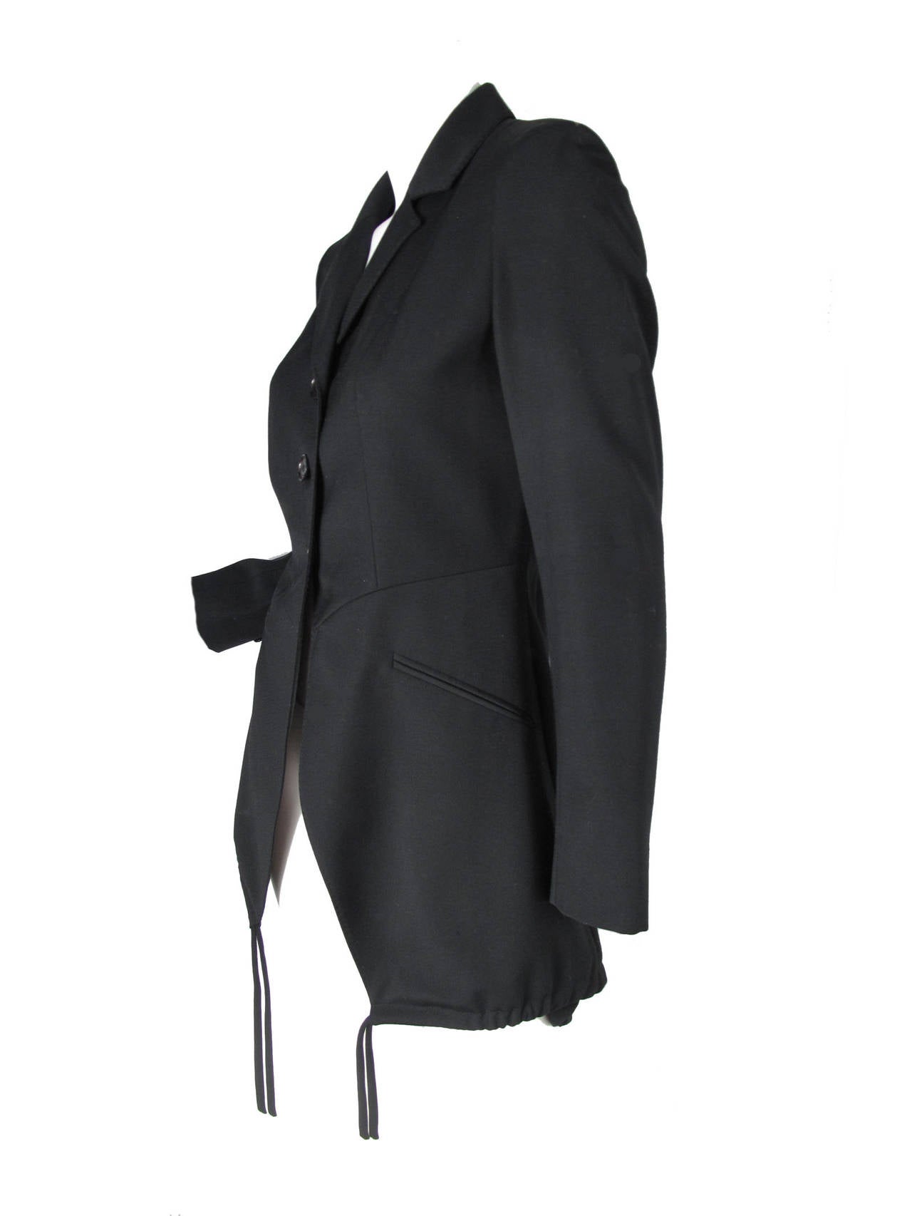 Moschino long black blazer with drawstring ties at hem on front and back.  Condition: very good, small pin hole in front, does not go through lining.   Size 8

36
