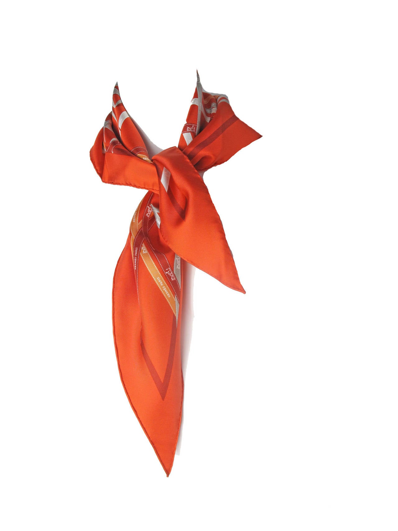 Hermes Bolduc ( hermes ribbon )  Print Red Silk Twill Triangle Scarf with Classic grey, and orange and dark red ribbon print. 

41 1/2