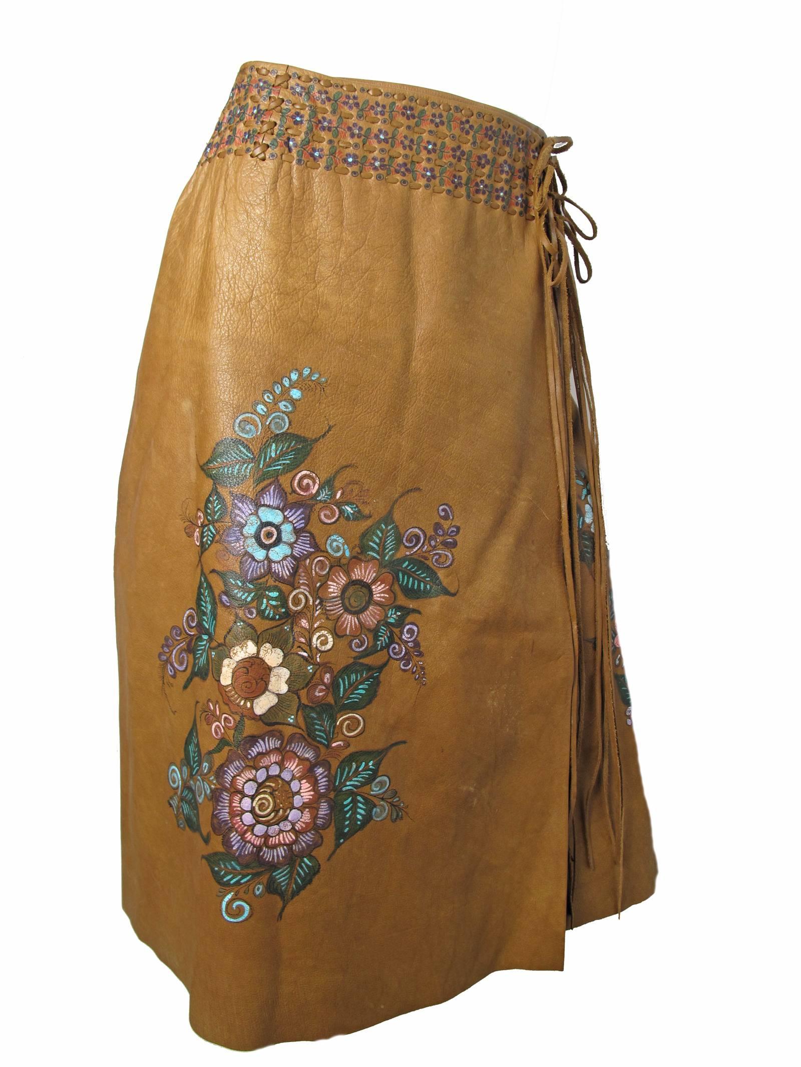 Early 1970s brown leather wrap skirt with hand painting.  Lacing on side.  Condition: Good, wear to paint and leather.  
Size 8 