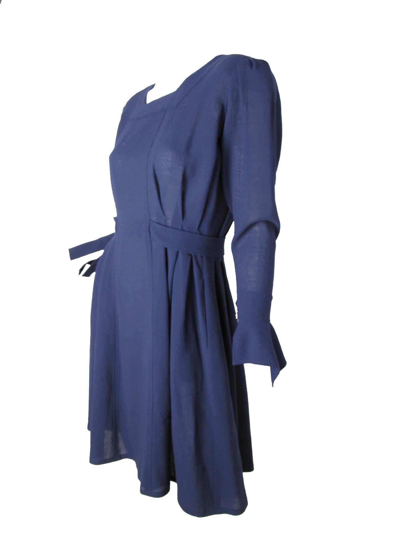 1980s Jean Muir navy blue crepe dress with attached belt. Pleating on sides. Pockets. Condition: Excellent.  Size US 6 UK 8
40