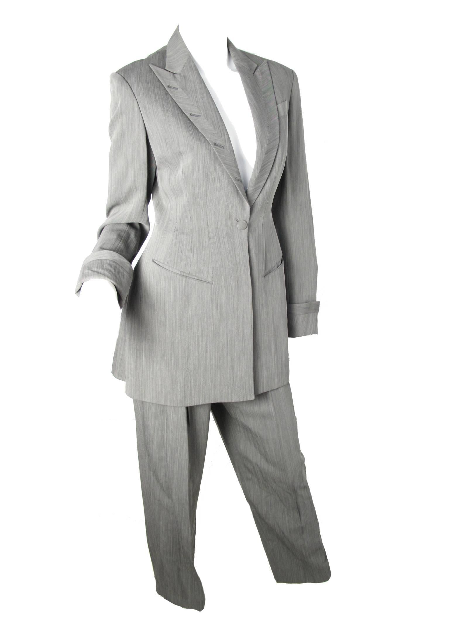Richard Tyler grey suit with front pockets and button holes up collar.  Viscose, wool, polyamide grey suit with silk lining. Made in USA. Condition: Excellent.  Size 4 
Jacket: 34