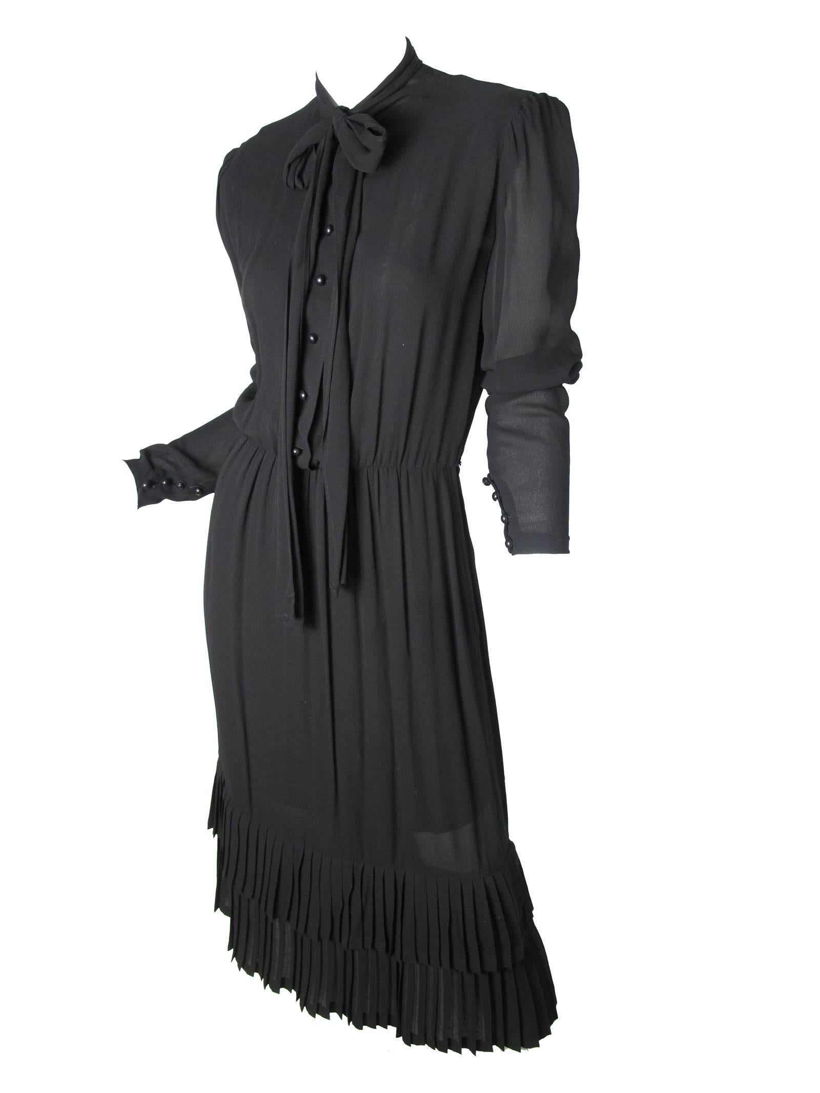 Schwarzes Seiden-Crêpe-Kleid von Scherzer mit Bindeband im Nacken und Rüschen am Saum. Zustand: Sehr gut, es fehlt der Originalgürtel.  Größe 6 / 8 

37
