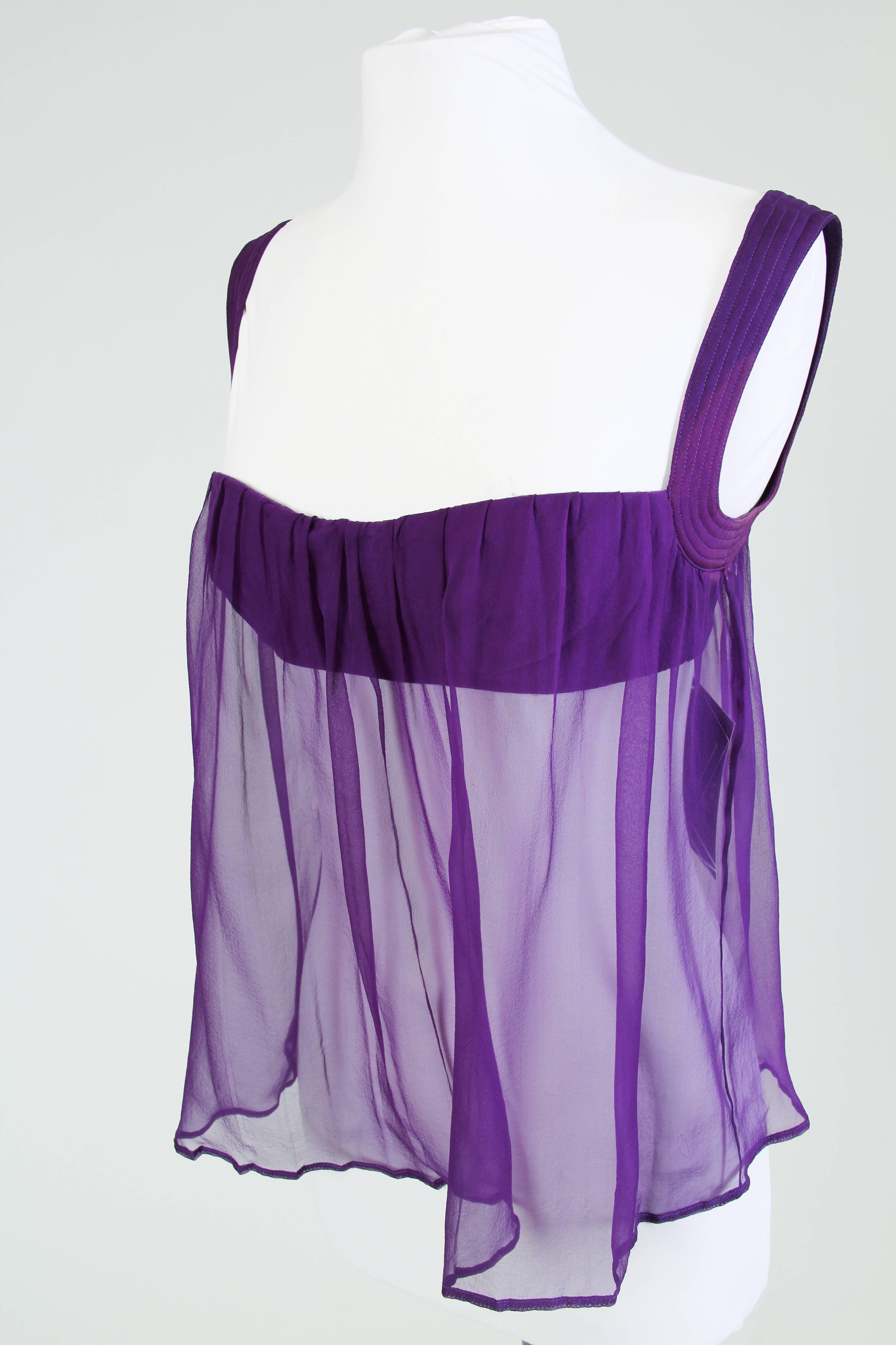 This sheer violet chiffon blouse is by famed design house Versace. The blouse is anchored by a royal purple bandeau-like bustier, supported by quilted silk strap-sleeves. A waterfall of chiffon in the same royal purple is pleated over the top edge