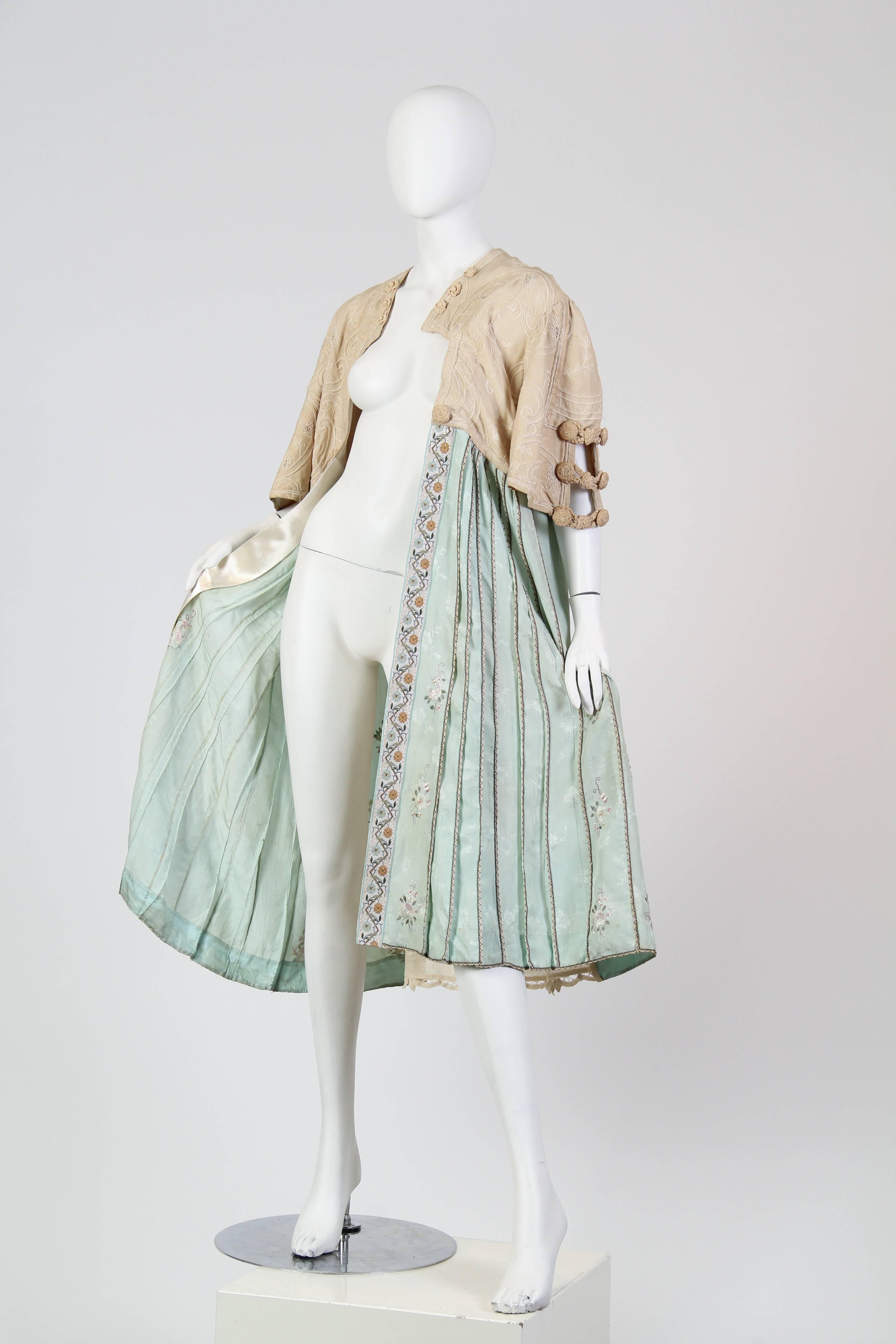 This is a gorgeous jacket, possibly dating from the early twentieth century and altered later. The top part, cut like a bolero, is made of a tan knit and covered all over in delicate corded lines in the shapes of flowers and abstract geometric