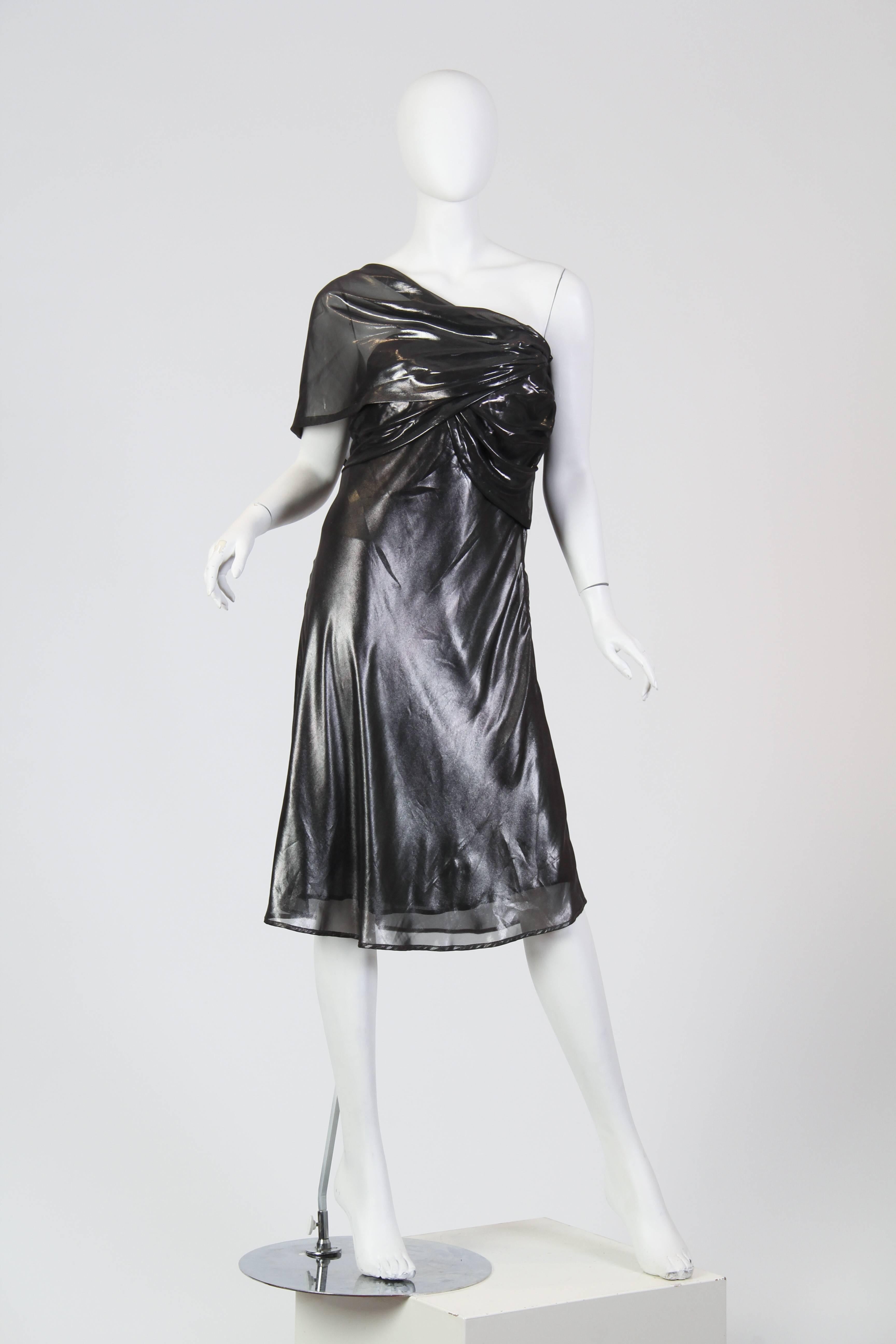 This is a striking satin dress by Krizia. In gunmetal-silver, the glimmering satin falls in flutes and gathers like liquid metal and smooth the curves of the body. Sheer gathered pieces highlight the bust and flow around the ribs and shoulders to