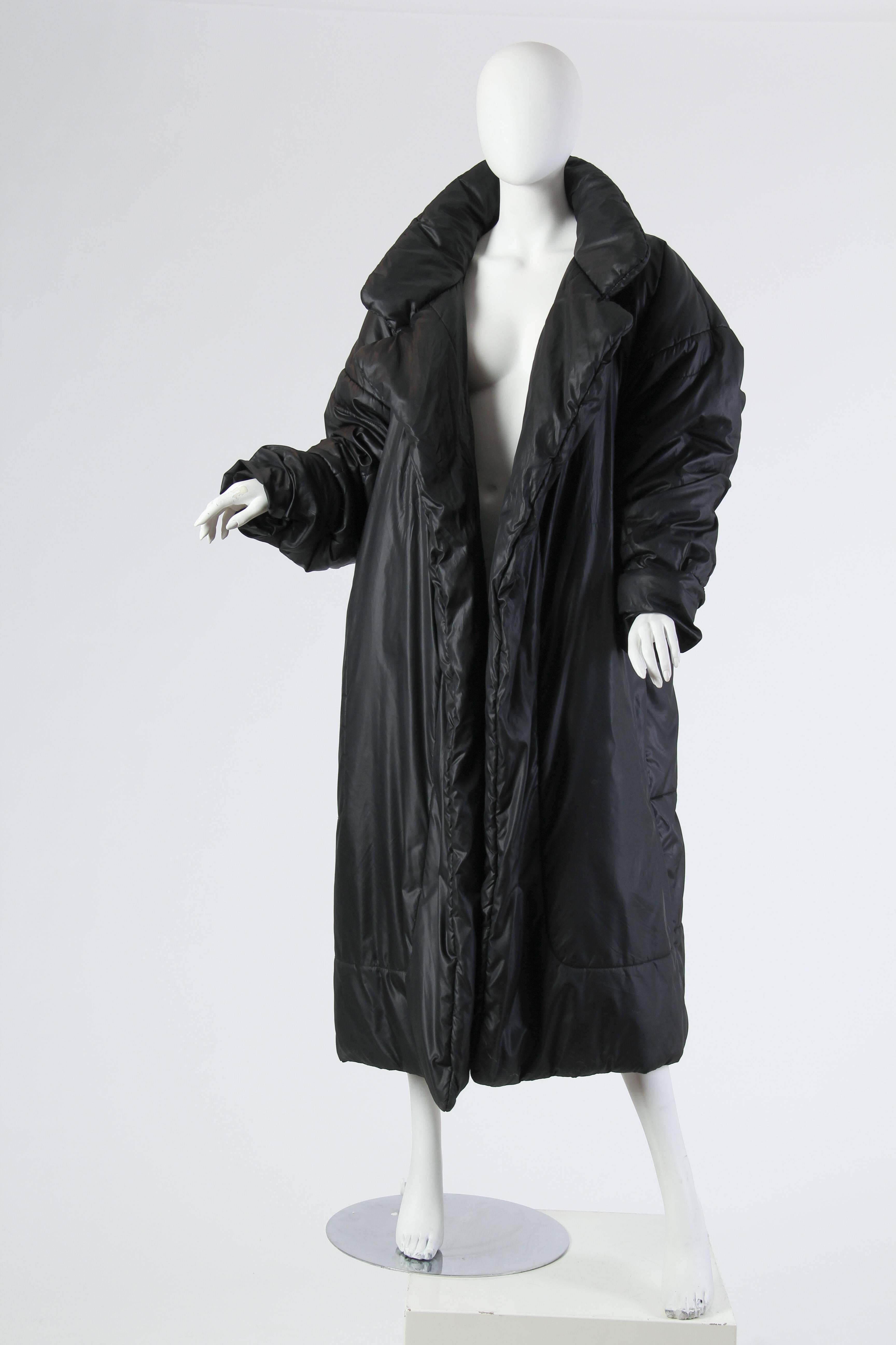 This is a sleeping bag coccoon coat by Omo Norma Kamali. This coat is as warm as warm can get, and turns its weather-appropriate bulk into clever and sophisticated styling. The coat's hem is detailed with curved border seams, drawing the eye down