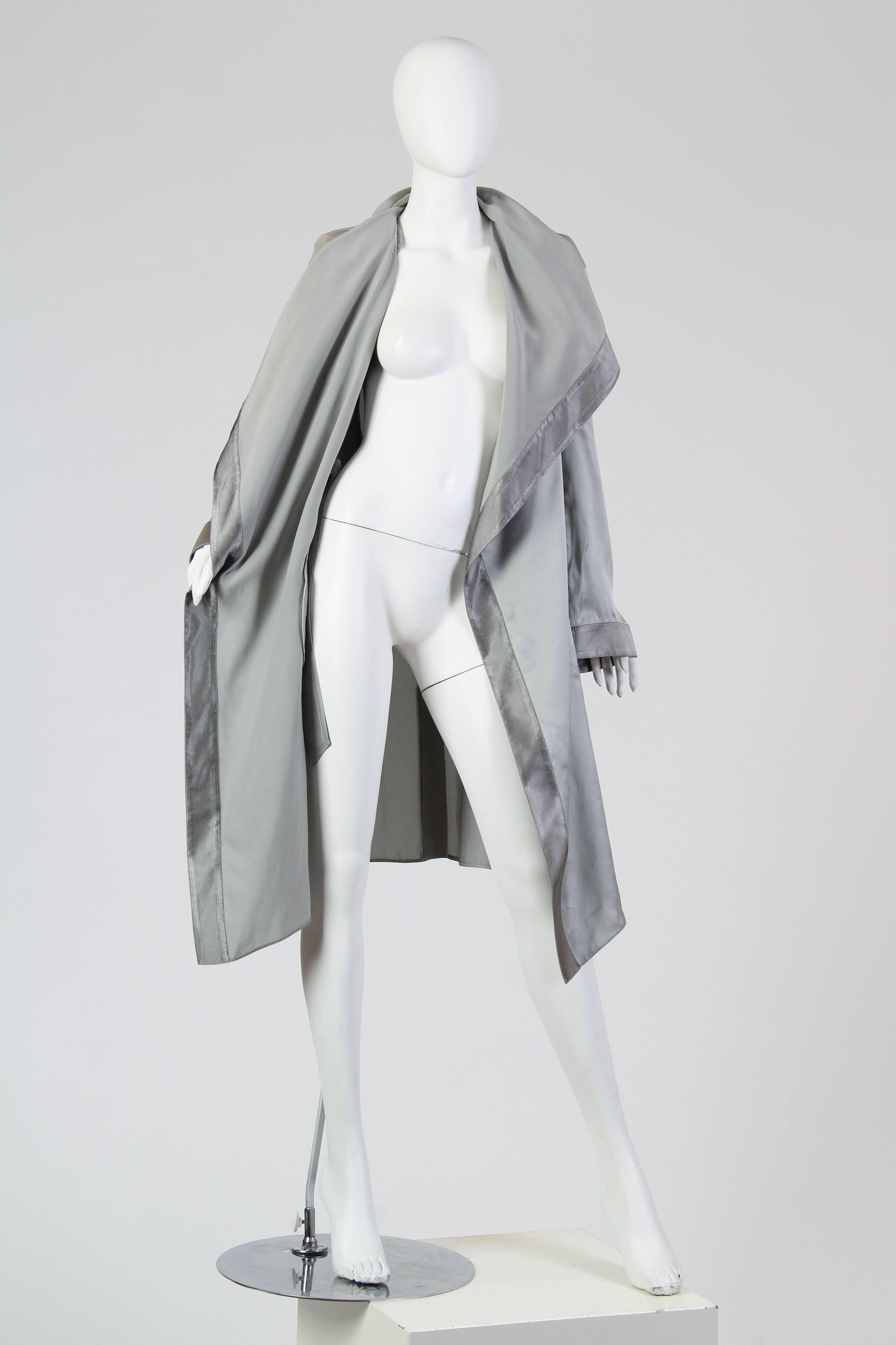 This is a wonderful trench coat of silver satin with a huge shawl collar. Darker satin borders define the edges of the coat without looking stark or jarring, and keep the silver looking elegant instead of glitzy. The fabric's natural drape has been