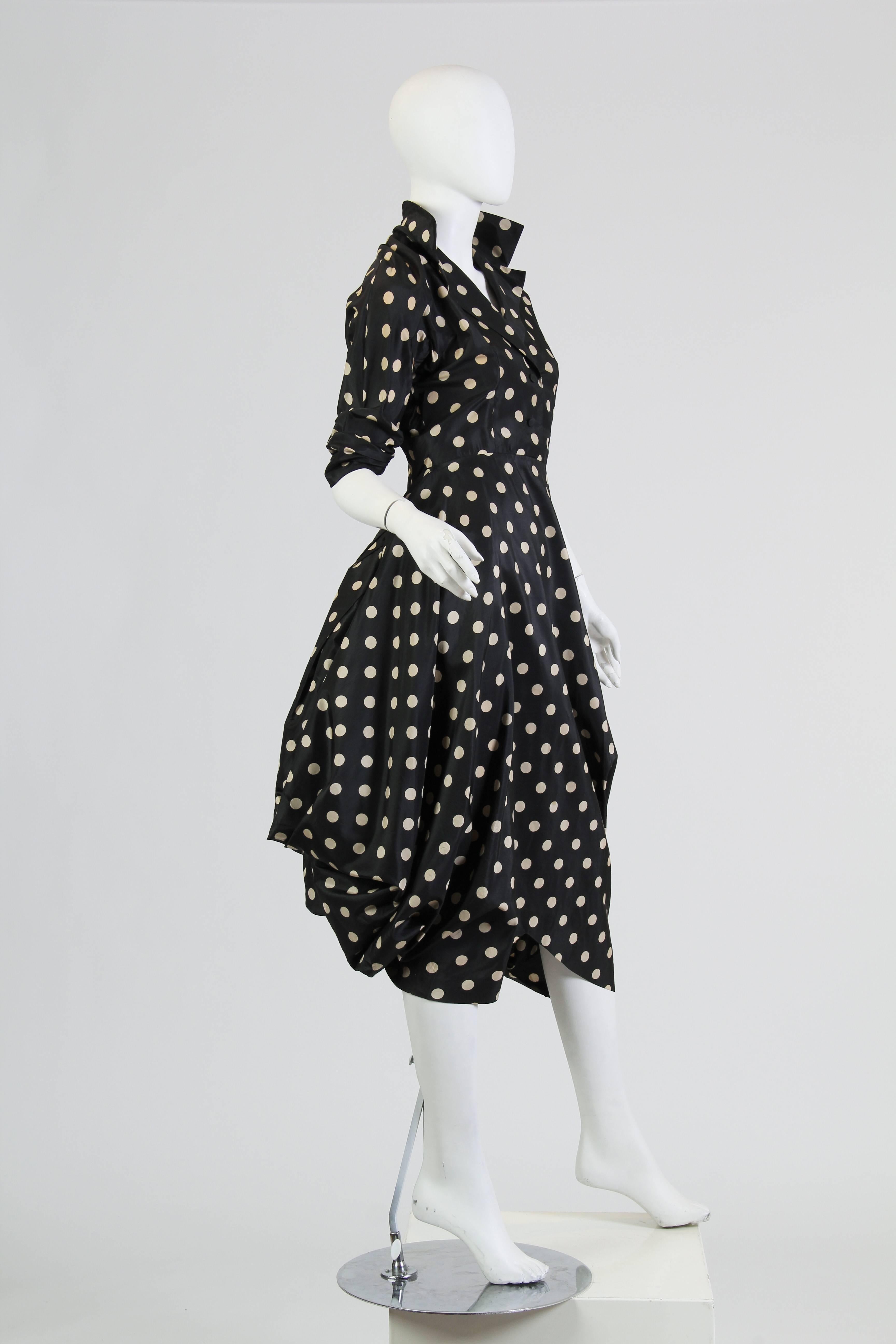 This dress is Very well made and finely detailed from richly bodies silk. This is an avant-garde reinvention of the classic 'Little Black Dress.' Its bottom layer, revealed at the bust and neckline, is a smooth black fabric with large tonal polka