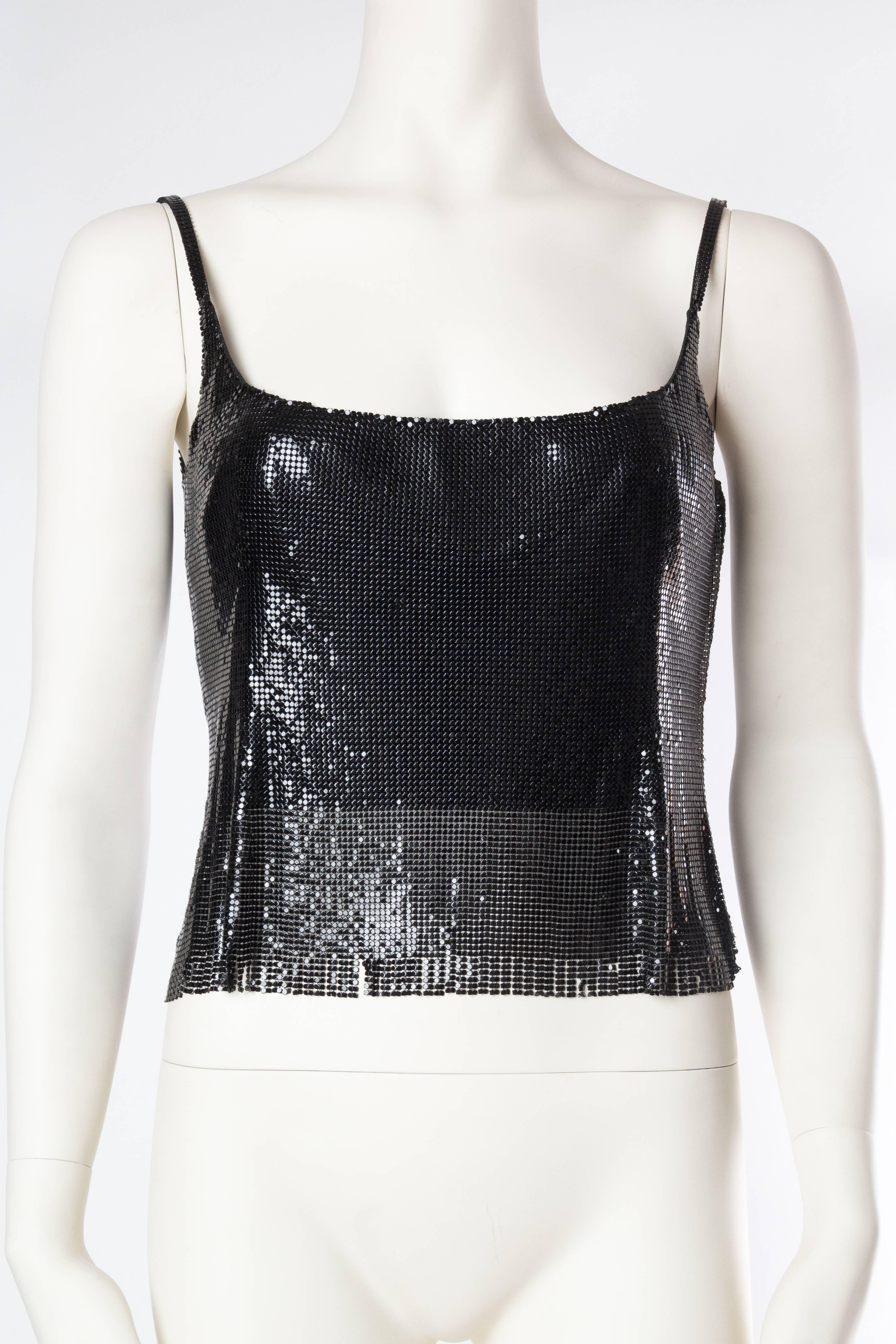 There is far more to the eye than just a black metal mesh top here. Gianni Versace is the only designer who painstakingly figured out a way to tailor the extremely tricky metal mesh to fit the curves of a woman's body. Numerous darts and tucks have