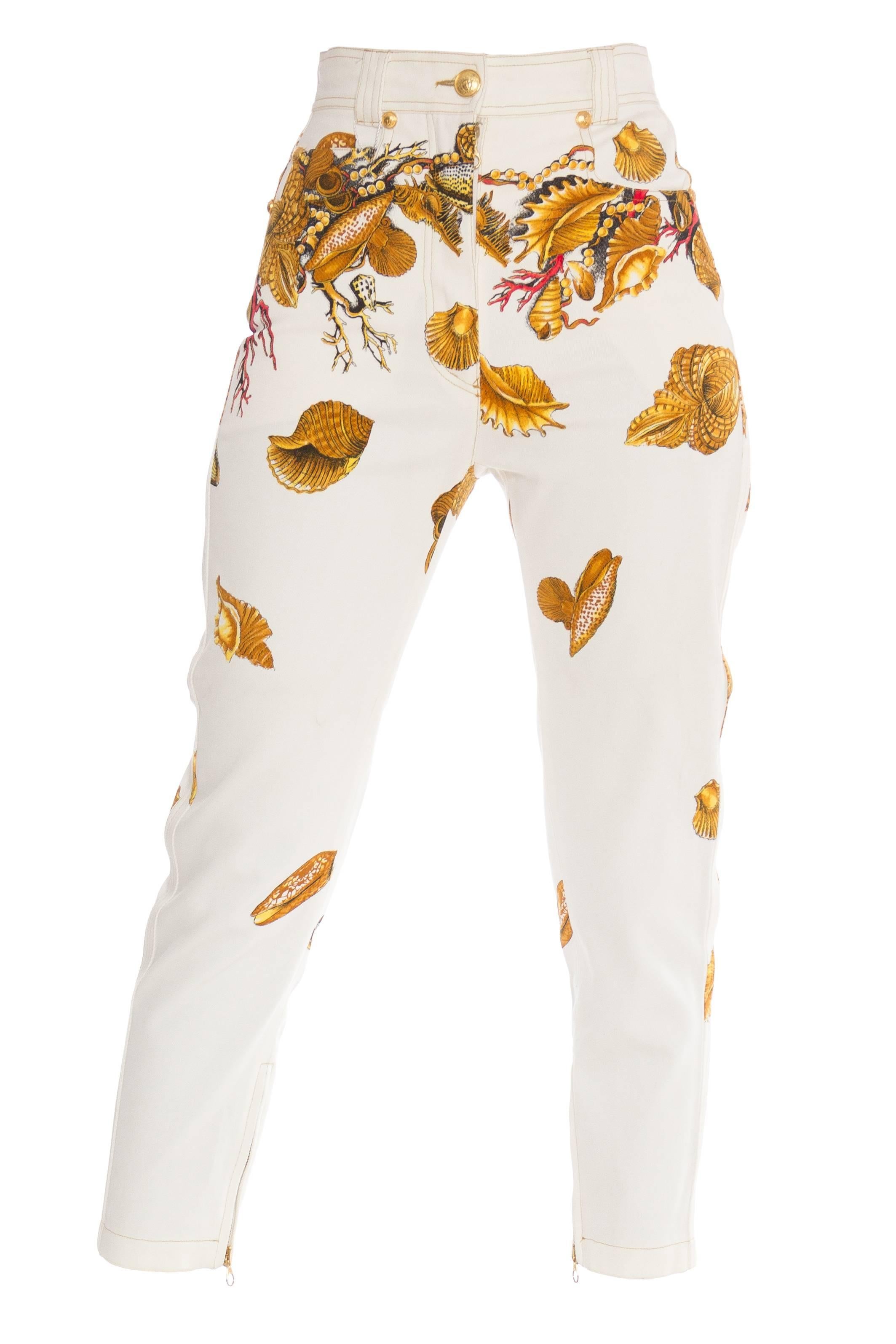 From the famous seashell and coral collection, these pristine white denim capris are stunners. Rendered in gold on white with gold zippers at the cuffs. Gold medusa button and rivets. Woven with a touch of stretch the high-waisted cut is so hot