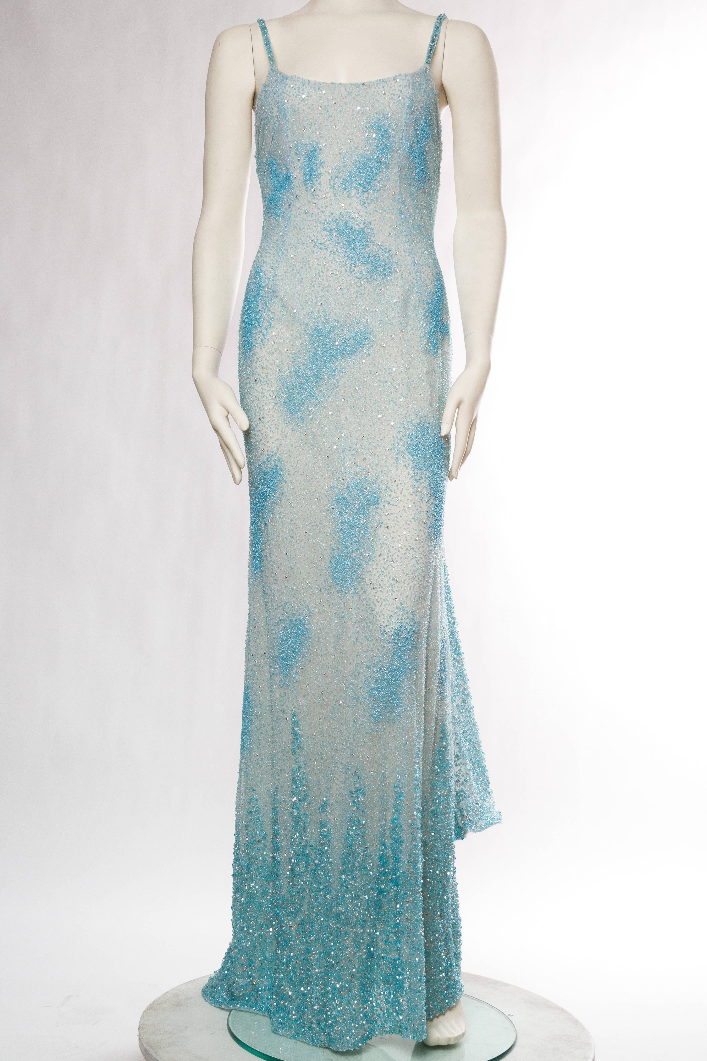 Gown is new with tags which with inflation would have made this gown over $80,000 when new. Truly a phenomenal find and in a great size. The sky blue gown has ages of hand worked beads and crystals upon it which dance and move across the body in