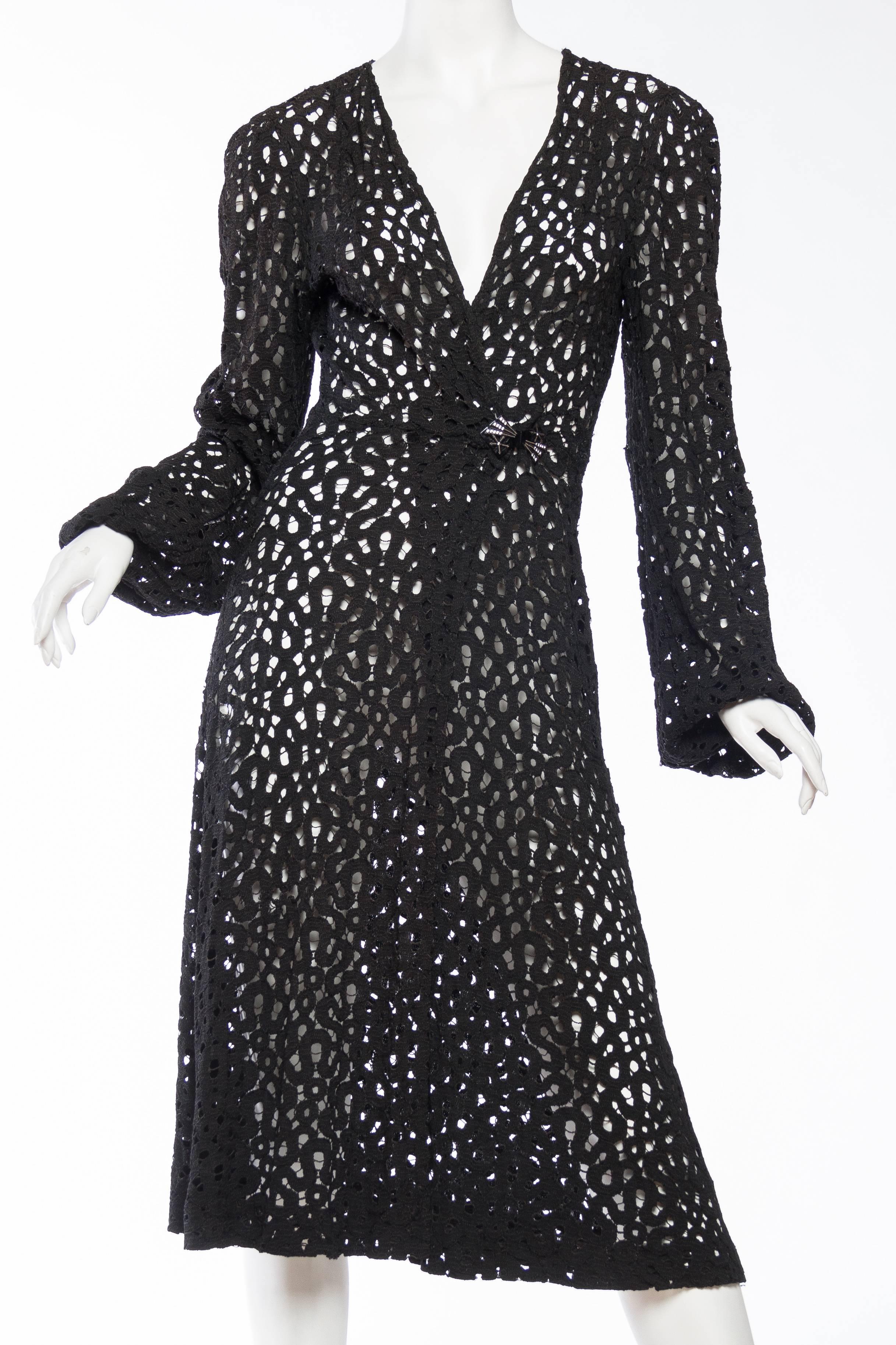 A lovely example of an early wrap dress, decades before Biba and St Laurent made them a wardrobe staple. Made from a unique lace in shades of black with an art deco clasp in the front. 