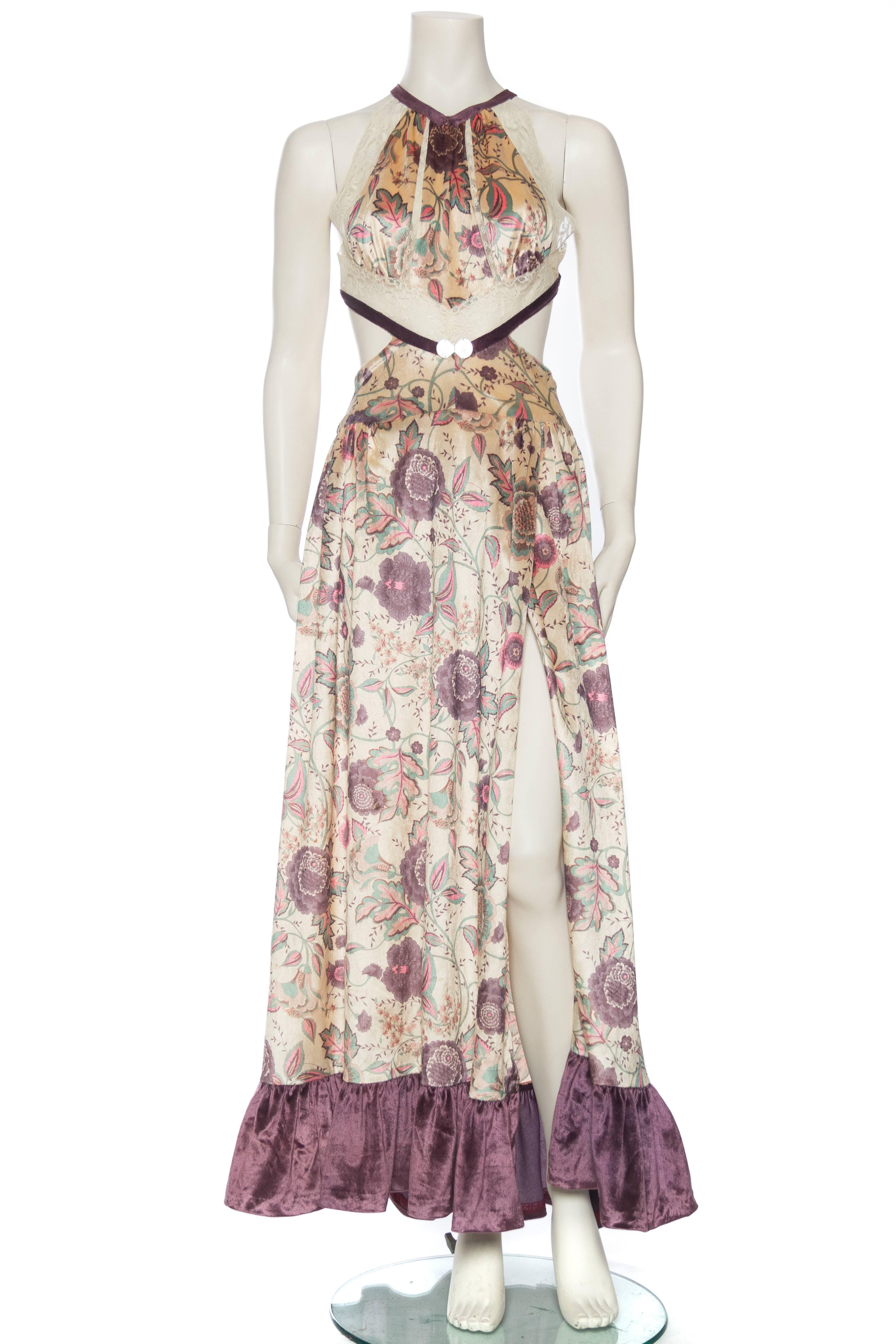 Made from 1970s printed silk velvet and Victorian lace. The cape can be worn snapped in on the sides to fit like a sleeve. Sexy wrap front design to the skirt for a flash of skin with a cut out back and zip in the center back. Antique art deco hand