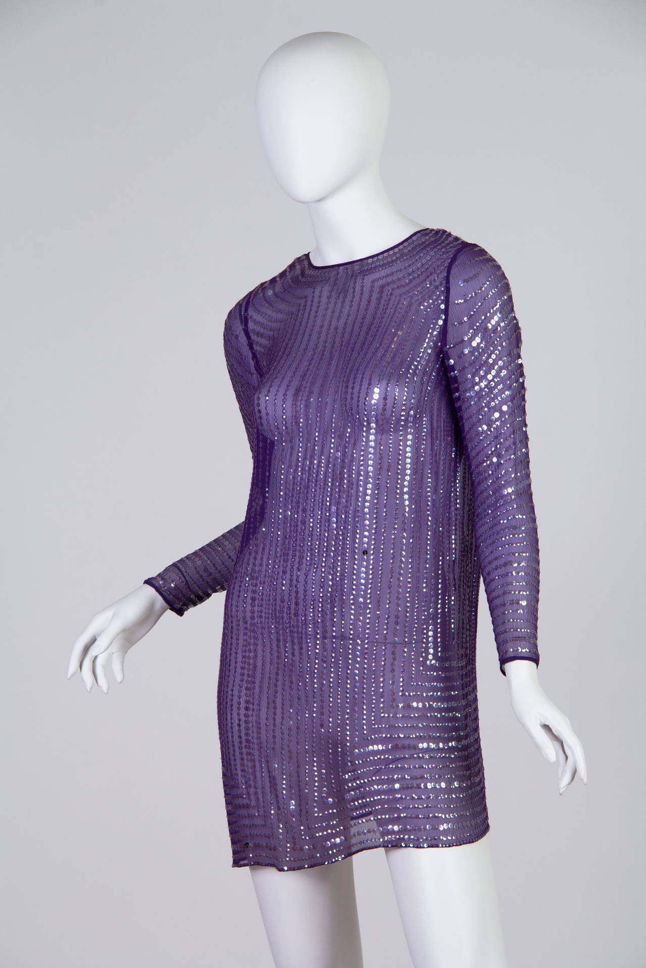 This sheer purple tunic dress by Halston is embroidered all over by hand with sequins. The straight cut of the torso and the architectural lines of sequins echo the aesthetics of the Jazz Age, when short and glittering gowns were favoured by