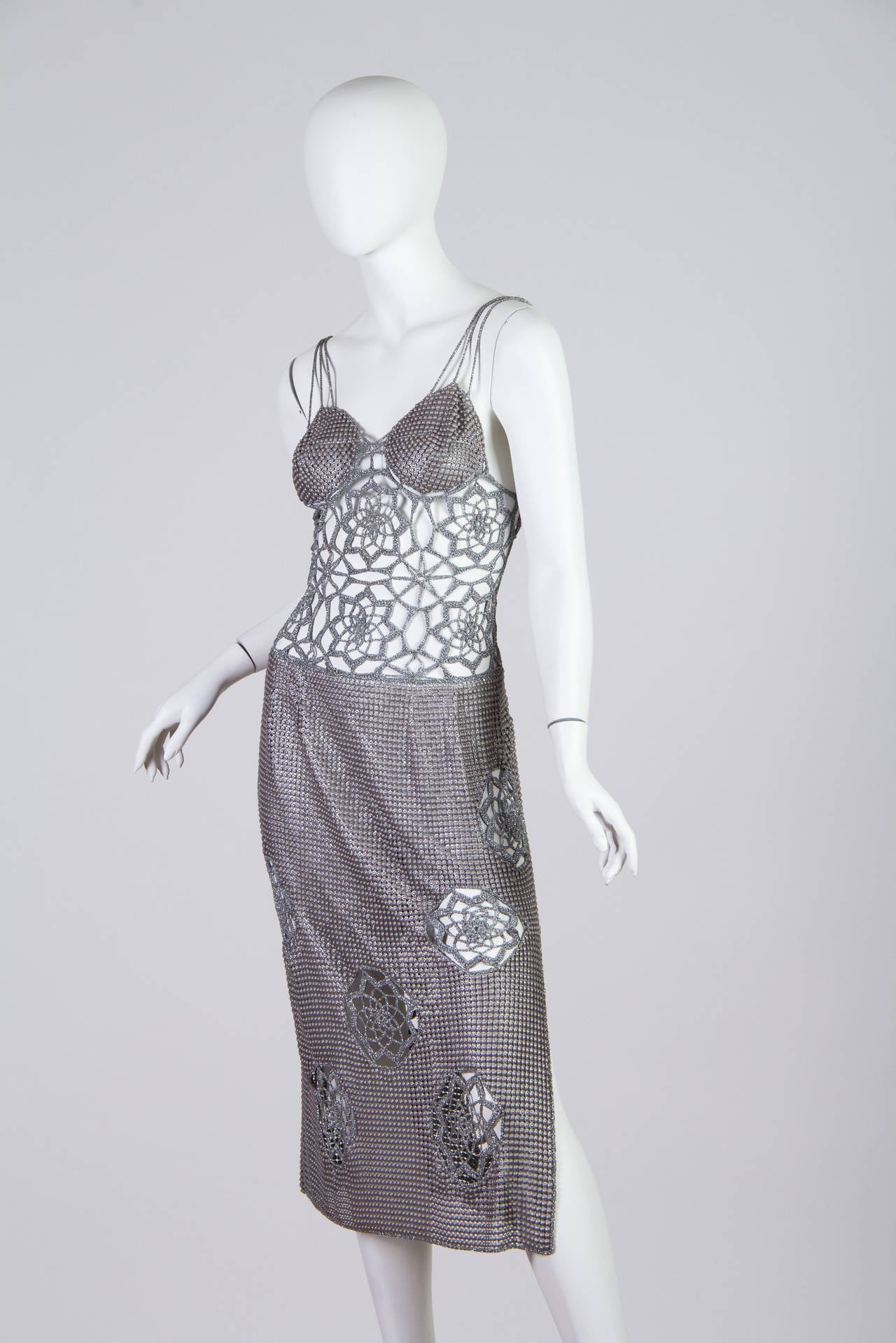 The design and construction of this dress is unheard of. The metallic lurex crochet builds the body, straps and insets in the skirt, the rest of the garment is made from a unique chain mail metal mesh. We are listing this piece as 1970s however it
