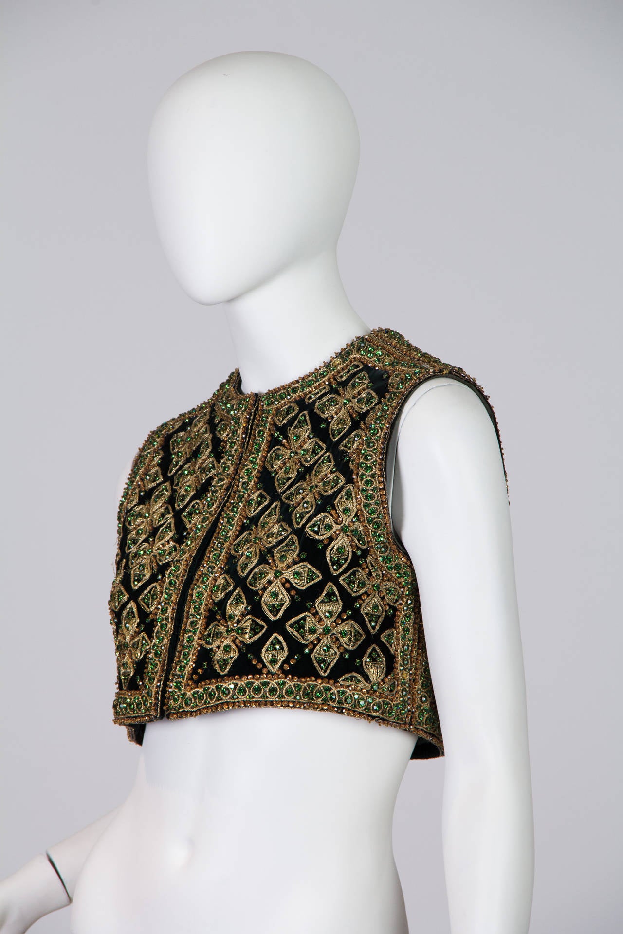 This jawdropping vest by Marie McCarthy for Larry Aldrich is made of heavily embroidered and beaded velvet and lined with shot emerald silk. The design, richly picked out in greens and golds, brings to mind a Byzantine mosaic or medieval stained