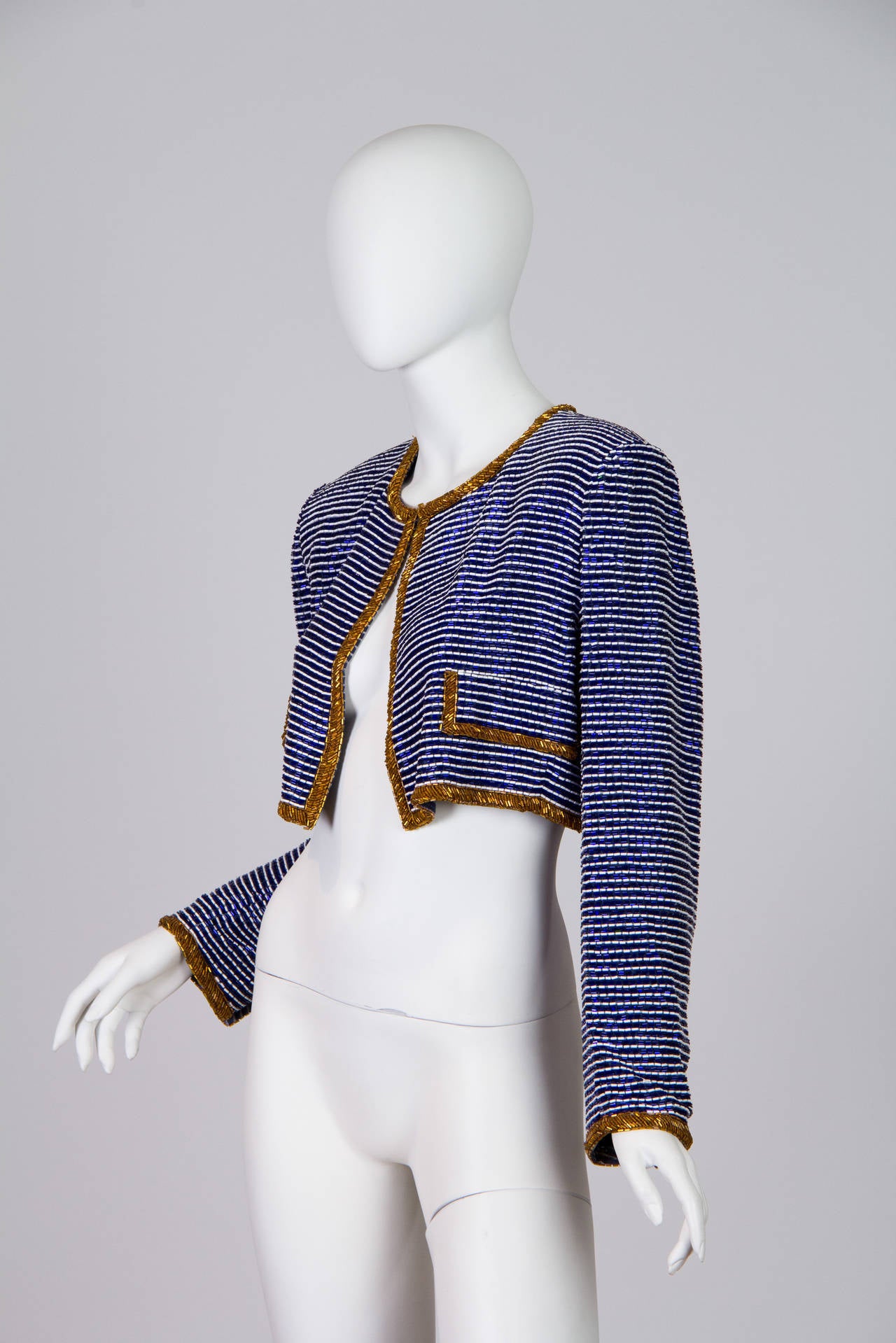 This is a couture jacket from the 1980s, by designer Russell Trusso. It is completely encrusted in blue, white, and gold beads which give it a wonderful weight and shine. The color of the cobalt makes this a statement jacket that will never be