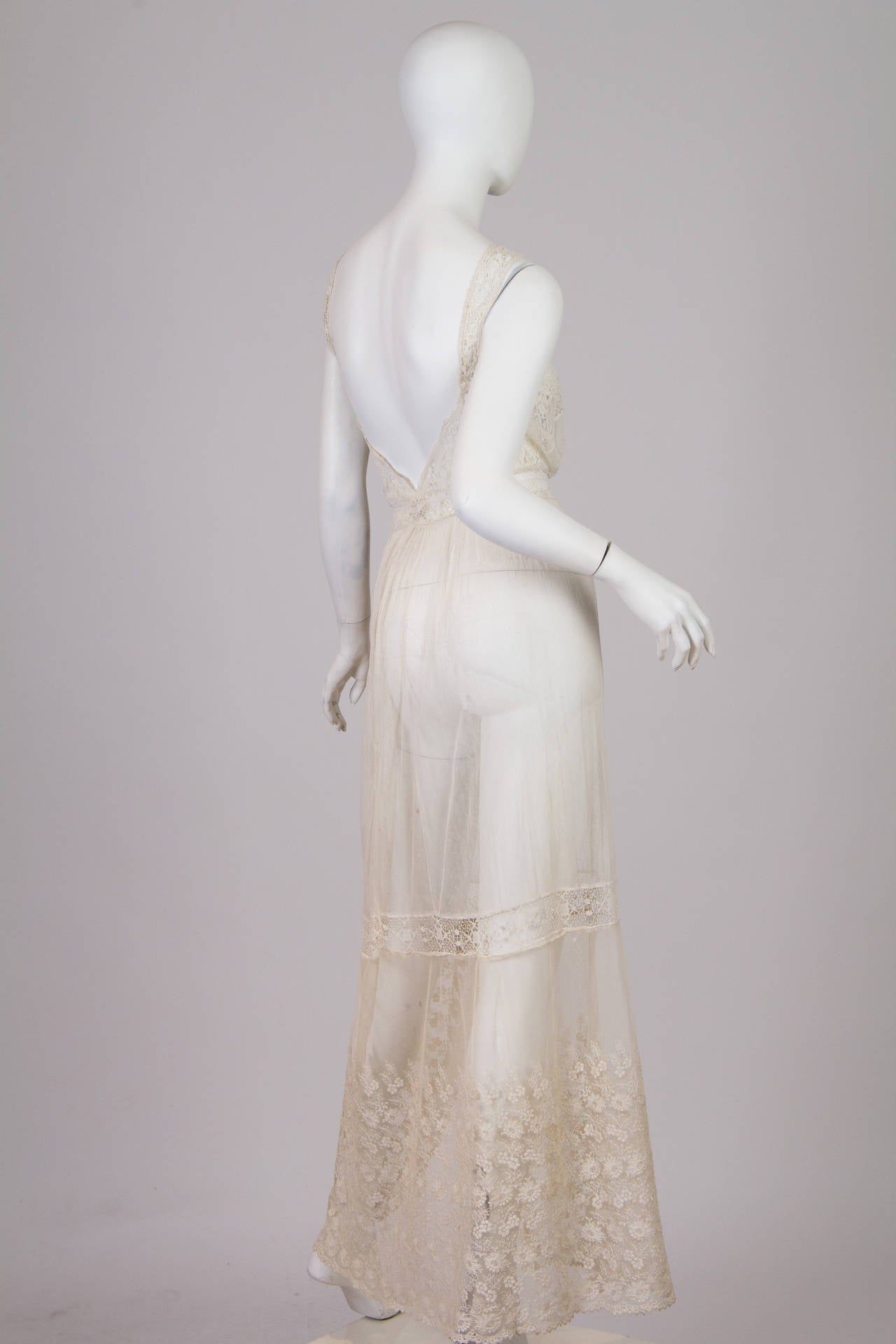 This dress in 100 years old, from around 1910-1915. We have altered it slightly to repair it. We have taken in some of the blousing from the front and lowered the back, updating it for todays woman. The slit is an interesting detail which is
