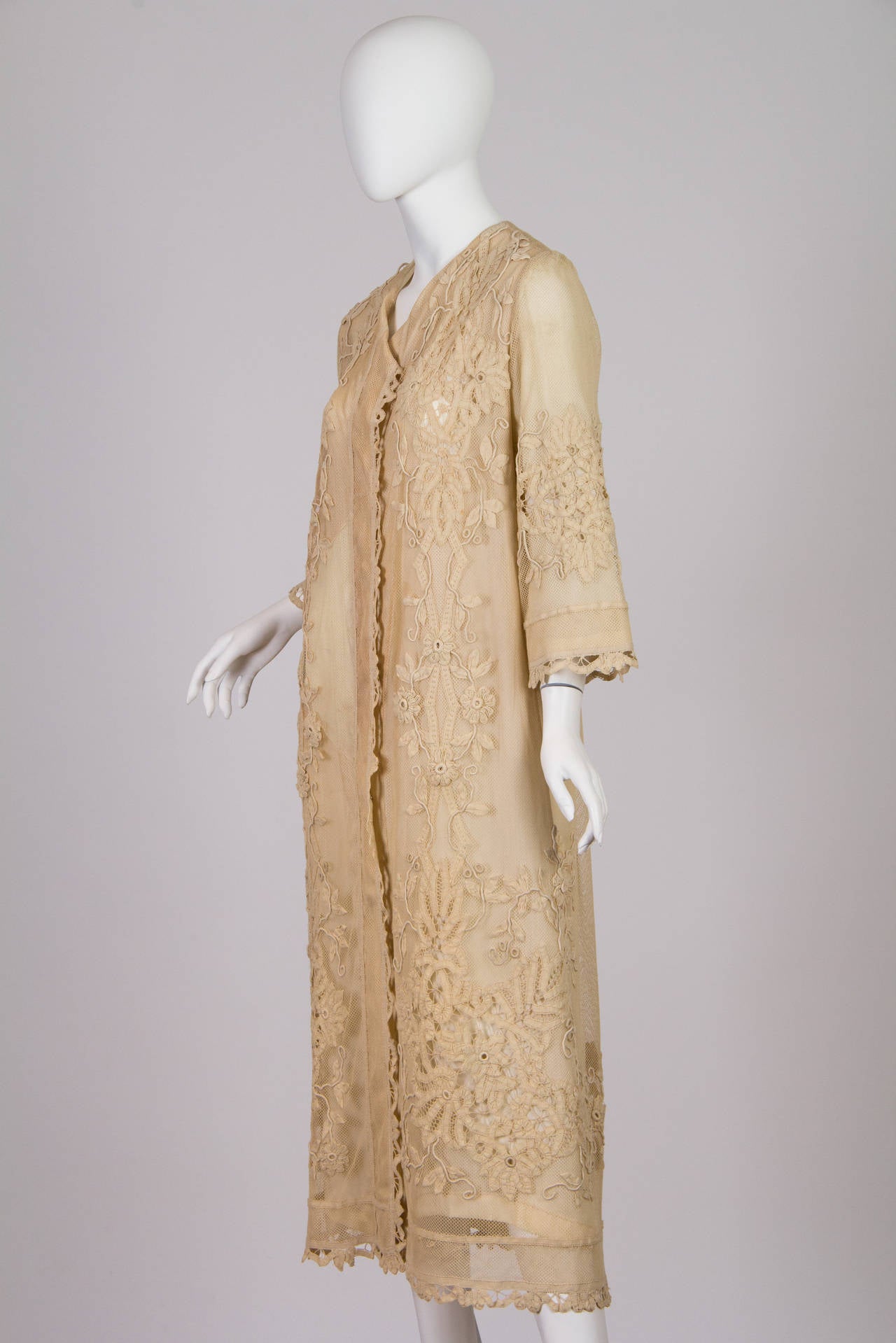 This is a lovely jacket-style dress made in the 1920s from earlier lace. The lace is a combination of Battenburg (or ribbon lace) and mesh, and is dark ivory in colour. The lace, while delicate in appearance, is in excellent condition. The straight