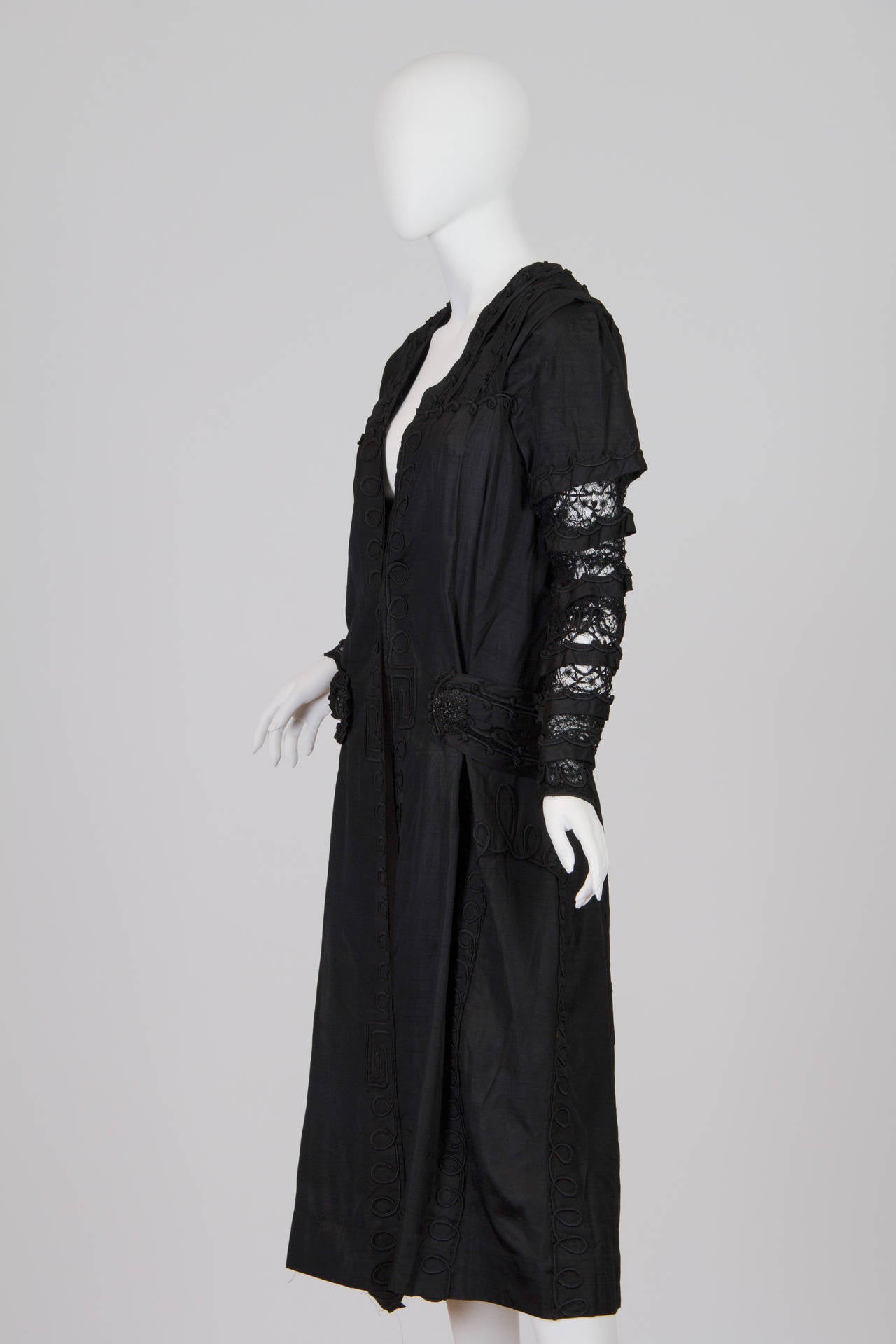 This piece is meant to be worn loose and away from the body with an internal waist stay. Some frayed edges and holes in the lace but no dry rot and is in strong and wearable condition. Edwardian Black Silk Dupioni & Lace Duster With Beaded Braided