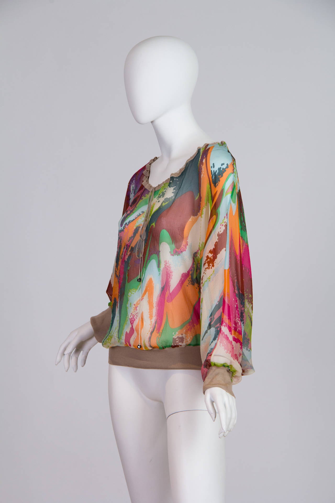 This is a bright and cheerful chiffon blouse by design house Missoni. Most well known for their complex knit designs, Missoni has diverged into a wider range of mediums with this blouse while still retaining their iconic patterns and colours, as