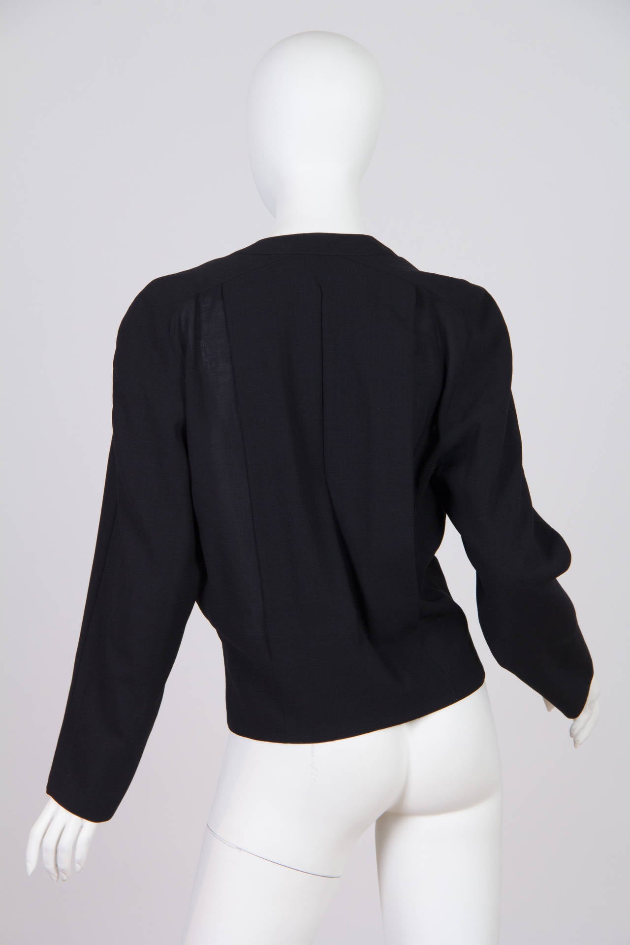 This jacket by Chloé has the silhouette of the 1980s, but also evokes the 1930s and 1940s. The dropped waist, vintage-style buttons and the careful draping around the bust bring to mind earlier styles of tailoring. The deep V neck keeps the