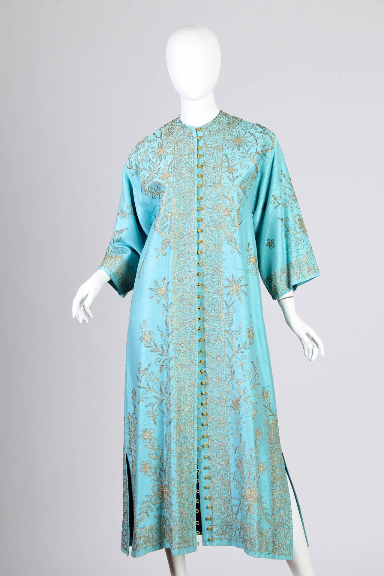 This is a beautiful Mediterranean-blue robe of traditional Lebanese origin. It is a simple T-shaped garment, with an embroidered neckline and wide, 3/4-length sleeves. The intricate gold embroidery is what makes this garment stunning, and it covers