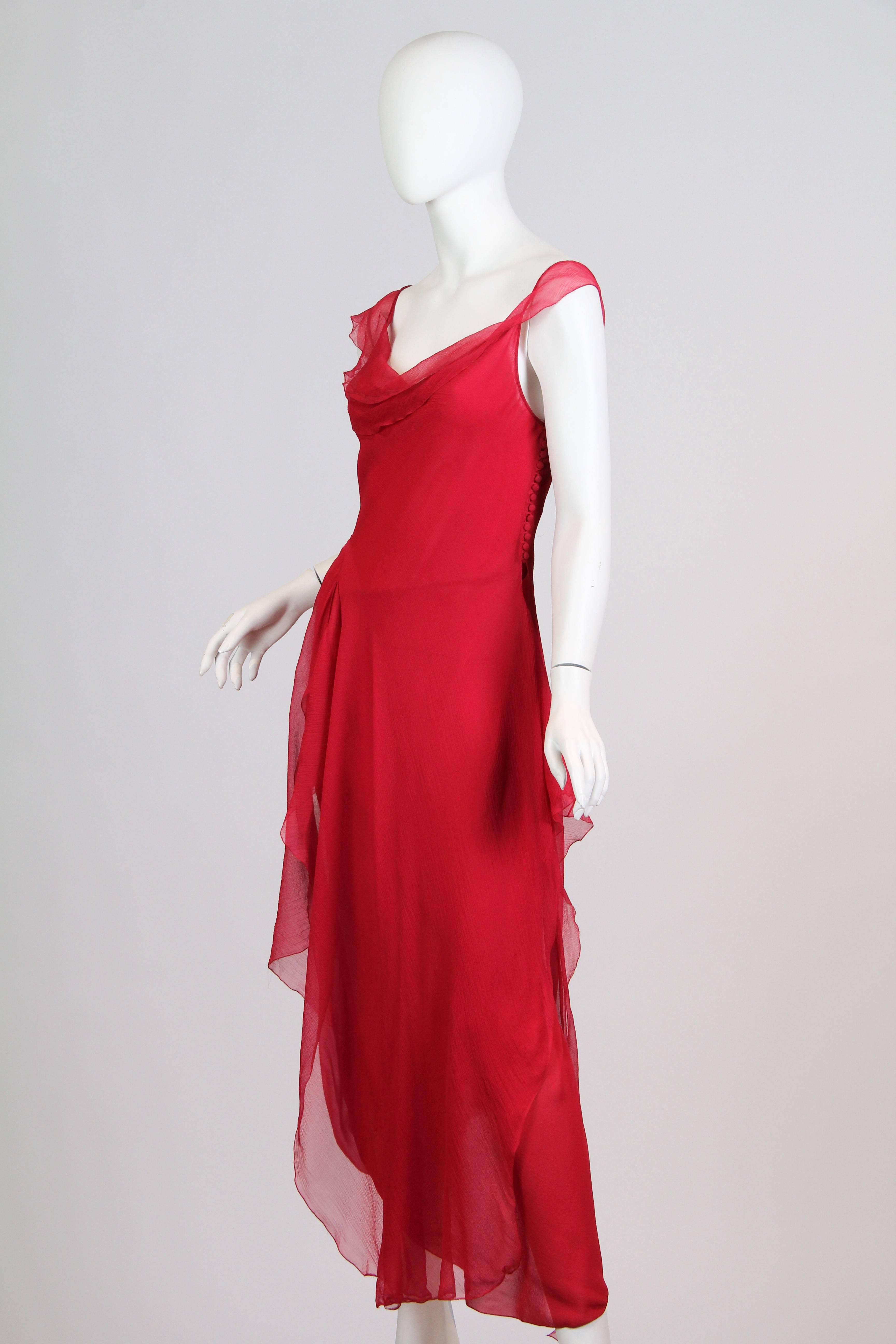 Iconic bias cut dress from John Galliano. Silk crepe de chine overlaid with delicate chiffon with asymmetrical ruffles and signature decorative row of buttons down the side.