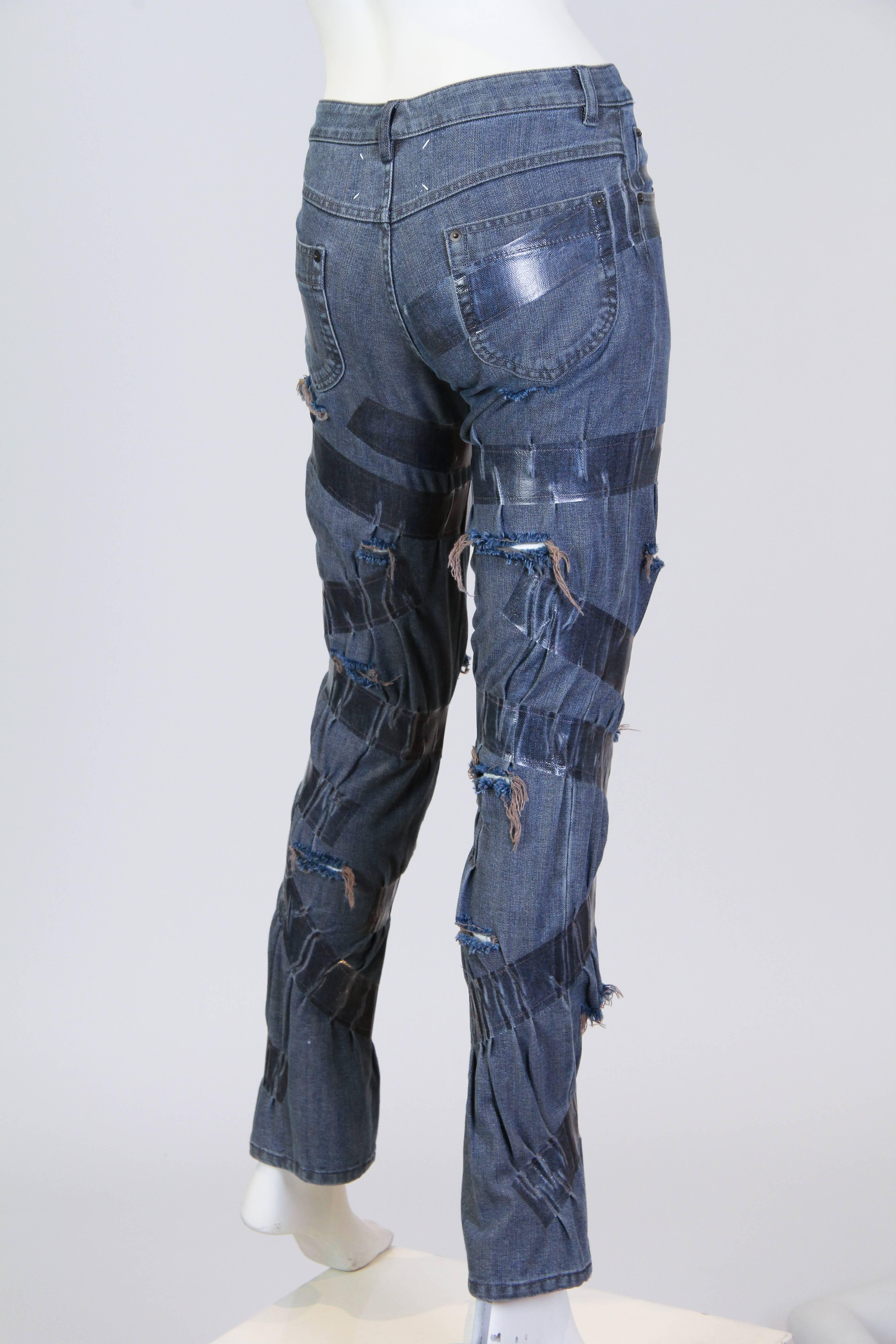 These jeans have been slashed and then "taped" back together by renowned designer Martin Margiela. The tape is actually a heat set plastic band which is permanent  and isn't sticky. 