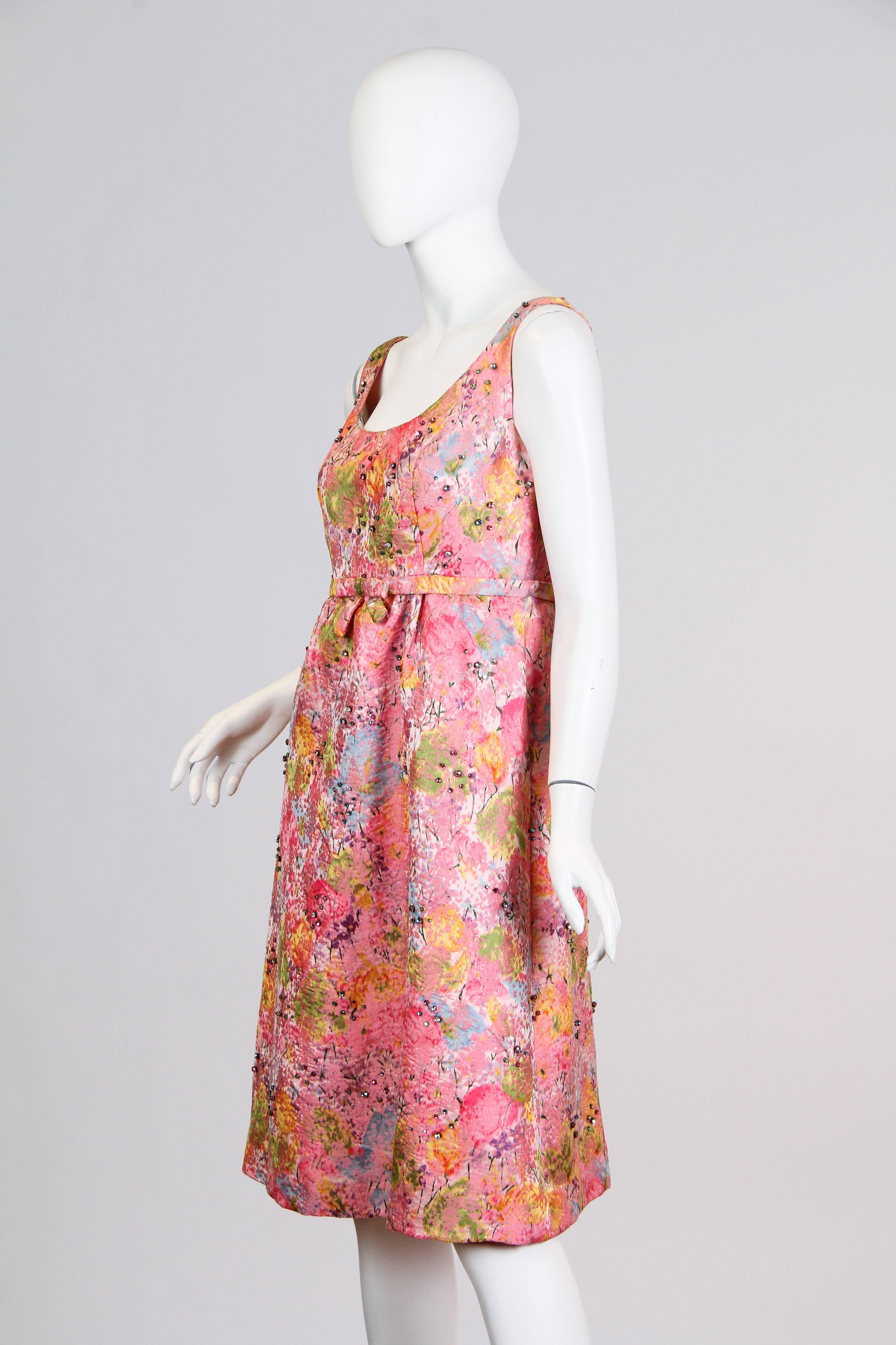 This textile is sensational, ikat printed silk which was then woven on a jacquard loom to add dimension and texture. Then the colors in the print are accented with colorful prong set crystals. Flattering clean and simple empire waisted cut. 1960
