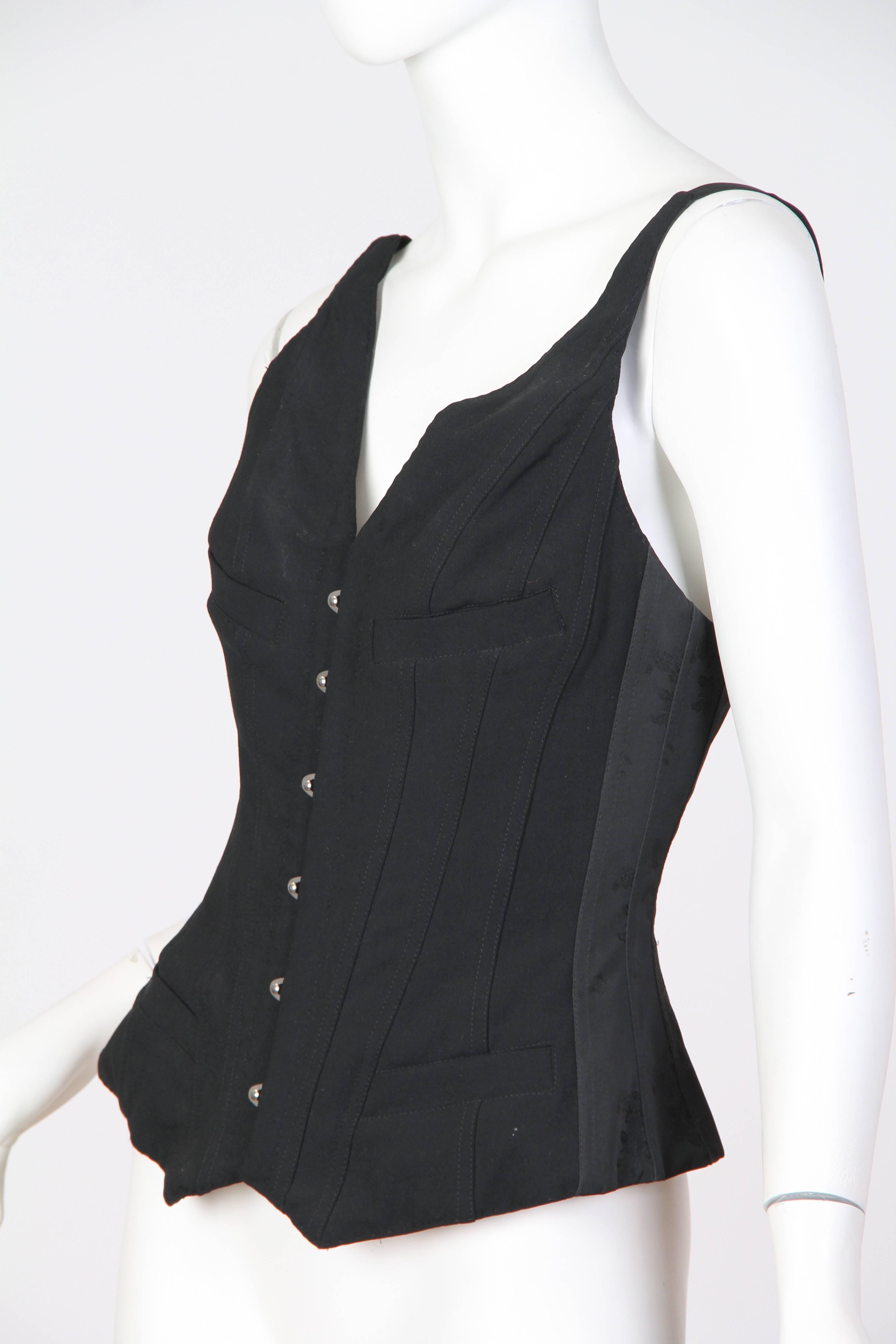 This is a stunning and sexy corseted waistcoat by respected designer Jean Paul Gaultier. Recently the design house has been exploring women's workwear, and experimenting with combining traditionally ultra-feminine garments such as corsets and