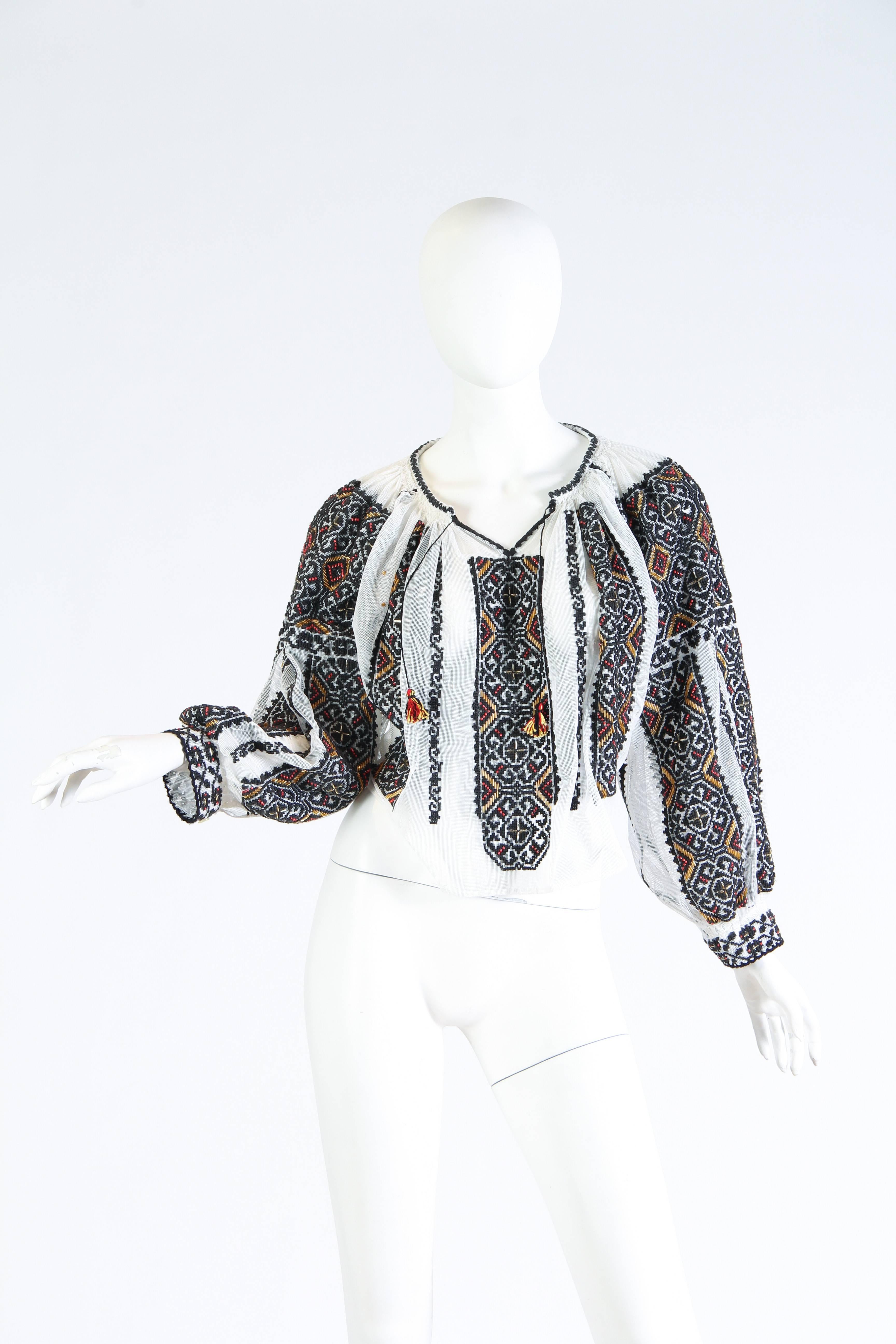 Dating from the mid century this Romanian blouse is perfection. The base material is a cotton net which has been painstakingly hand embroidered and beaded for days to achieve this level of embellishment. A rare gem in phenomenal condition. 