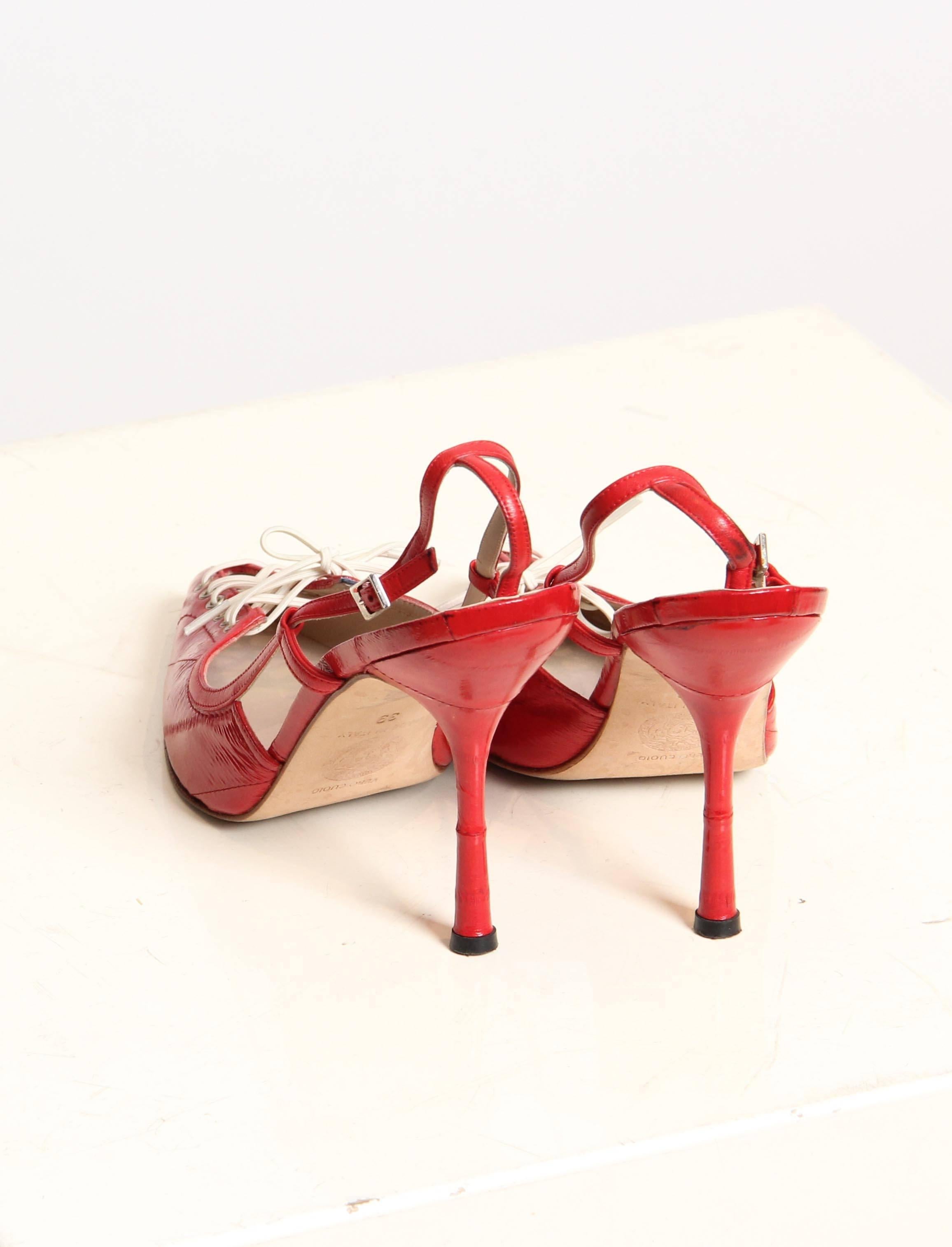 These are a pair of scarlet strappy heels by famed designer Gianni Versace. Made of a supple red eel leather, their pointed toes are laced up like a running shoe for a flirty peek and a charming sporty reference. The toe portion is seamed in a