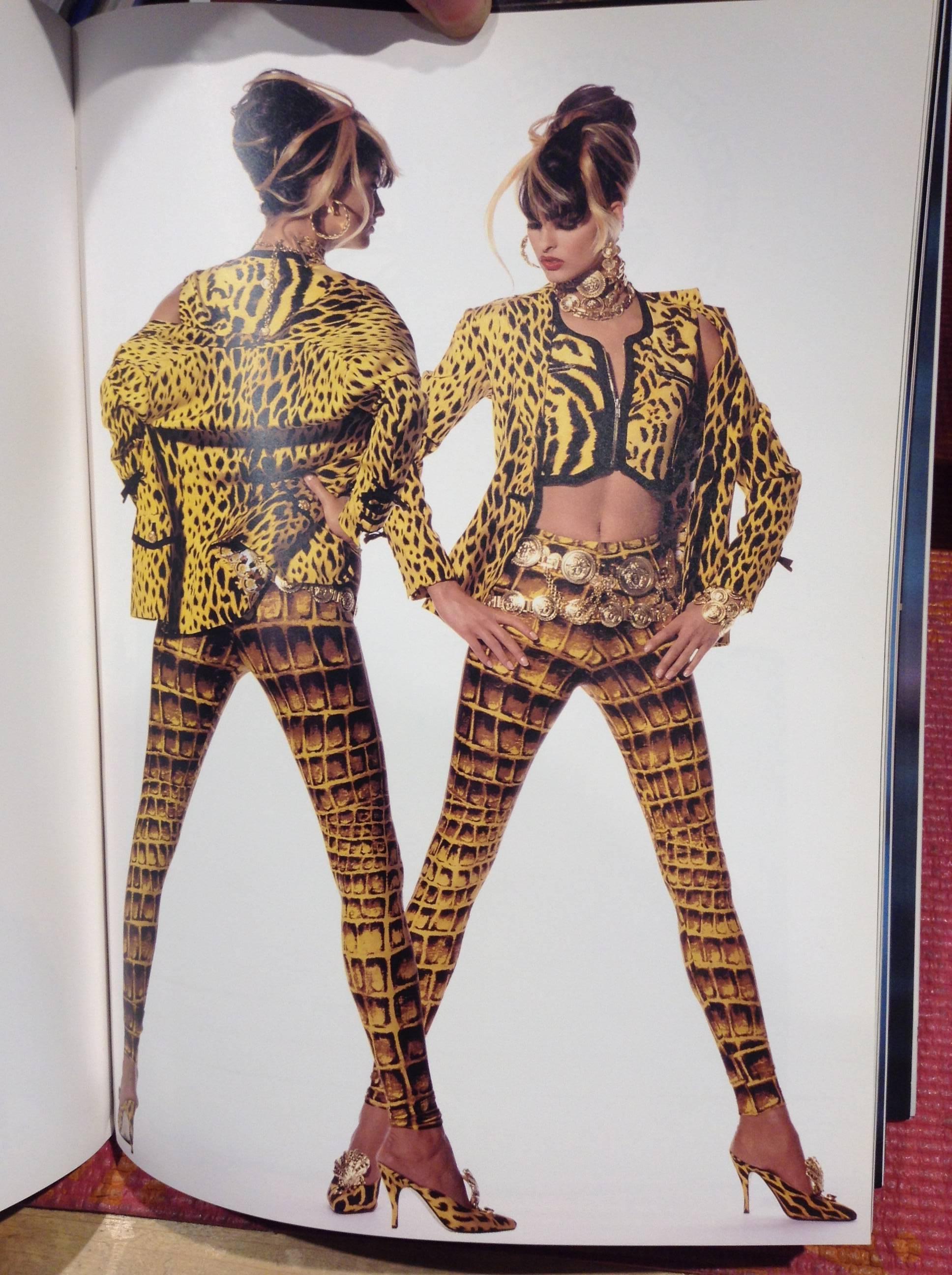 This is an ocelot-patterned cropped vest by famed design house Versace. The golden-yellow and black design is accented with exposed zippers, which mark pockets just above the bust and close the vest up the front. The smoothly angular design echoes