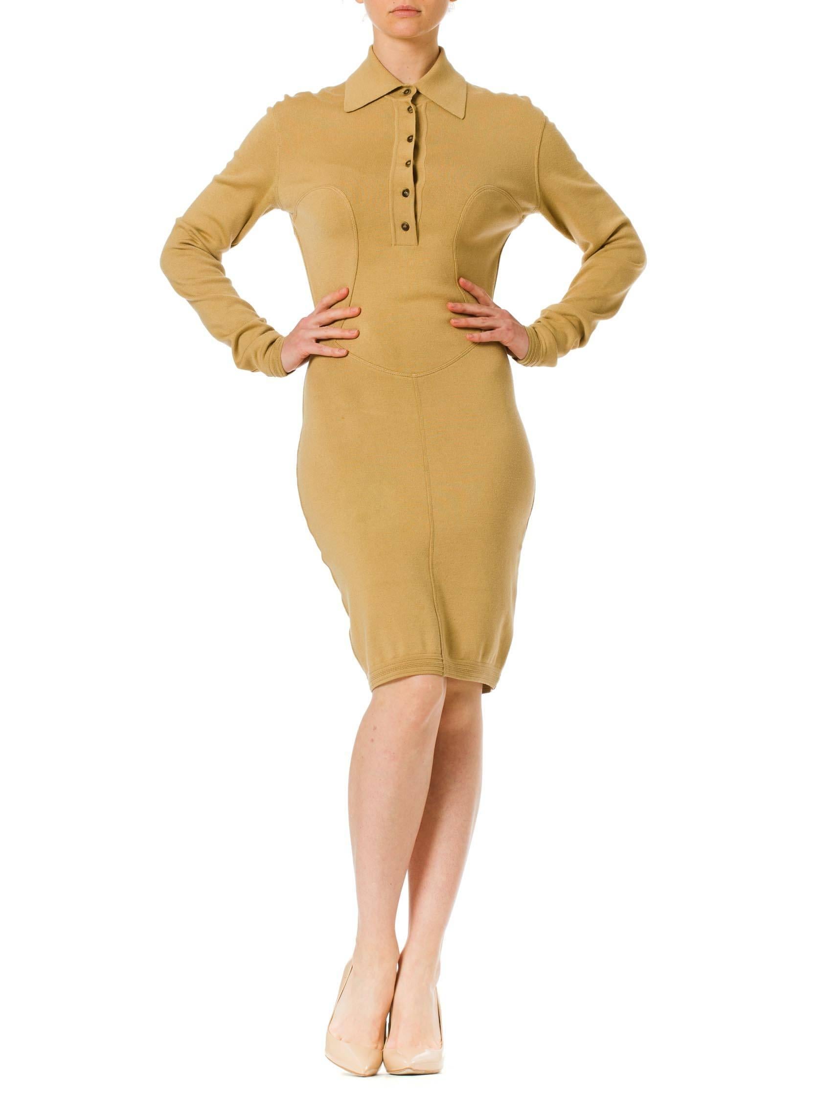 This is a tan jersey knit day dress with a plunging button-up neckline and complex seamlines. The princess-line seams over the bust extend into a v-bottomed inset over the hips, and finally a vertical seam down center front to the hem. These lines