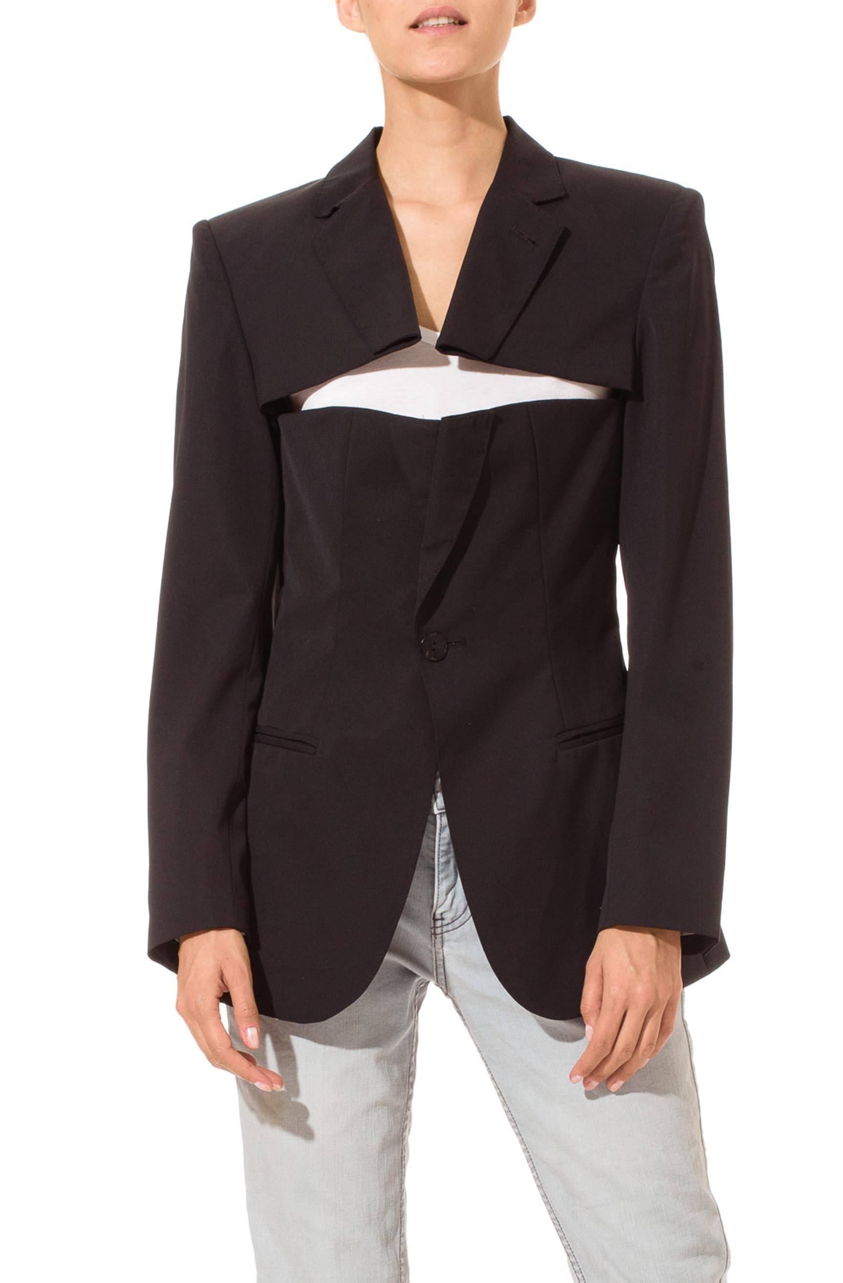 This is a blazer from Jean Paul Gaultier’s famous line of bustier- and corset-inspired blazers. Brilliantly designed and ingeniously constructed, this jacket is made to look as if a suit jacket has been slashed open above the bust to become a
