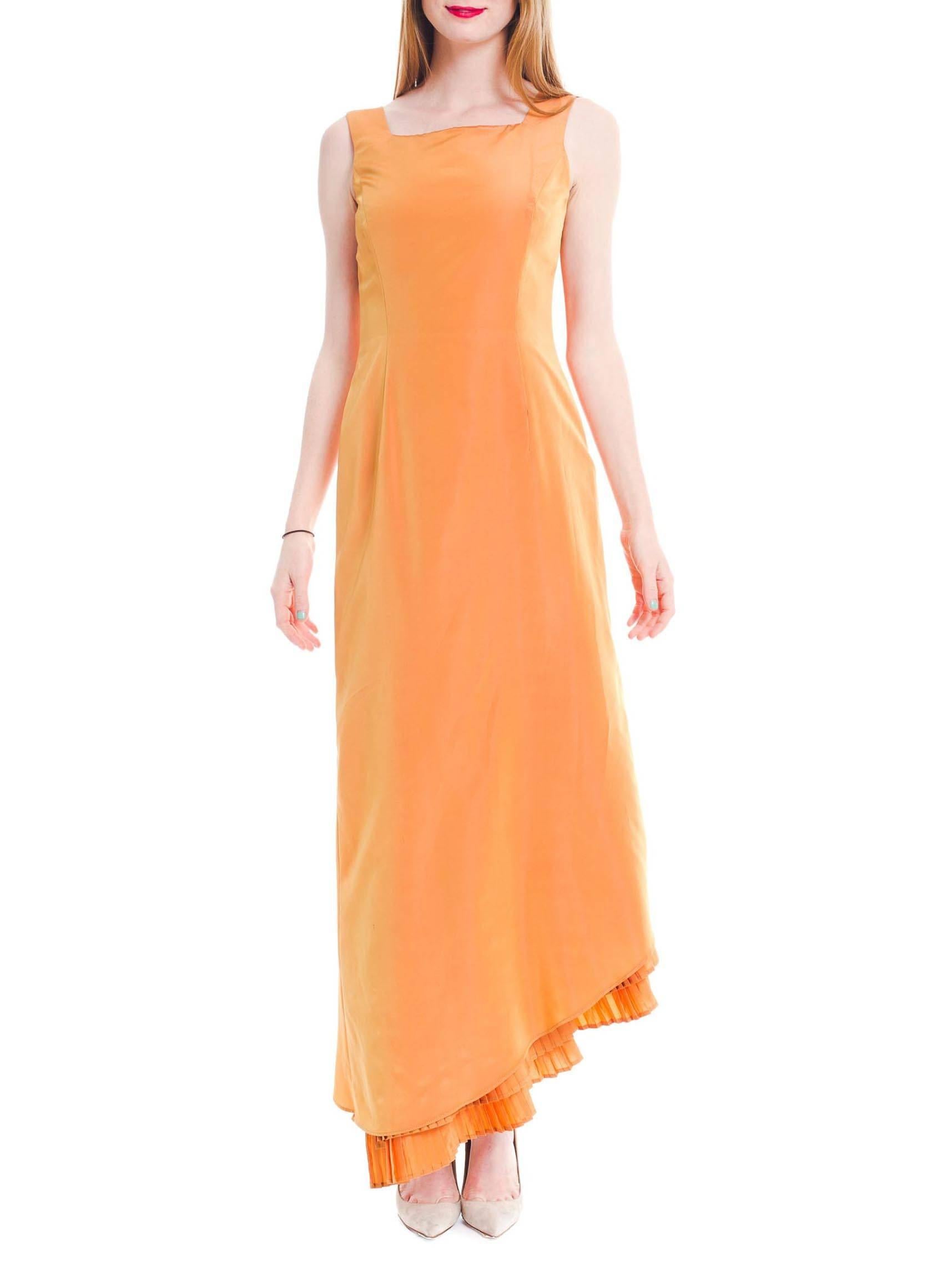 This is a stunning peachy-orange taffeta gown from Gianfranco Ferre's Studio collection. From the front, the elegant slim A-line cut looks deceptively simple. The square neckline is complemented by the rows of perfect knife-pleats which peek out