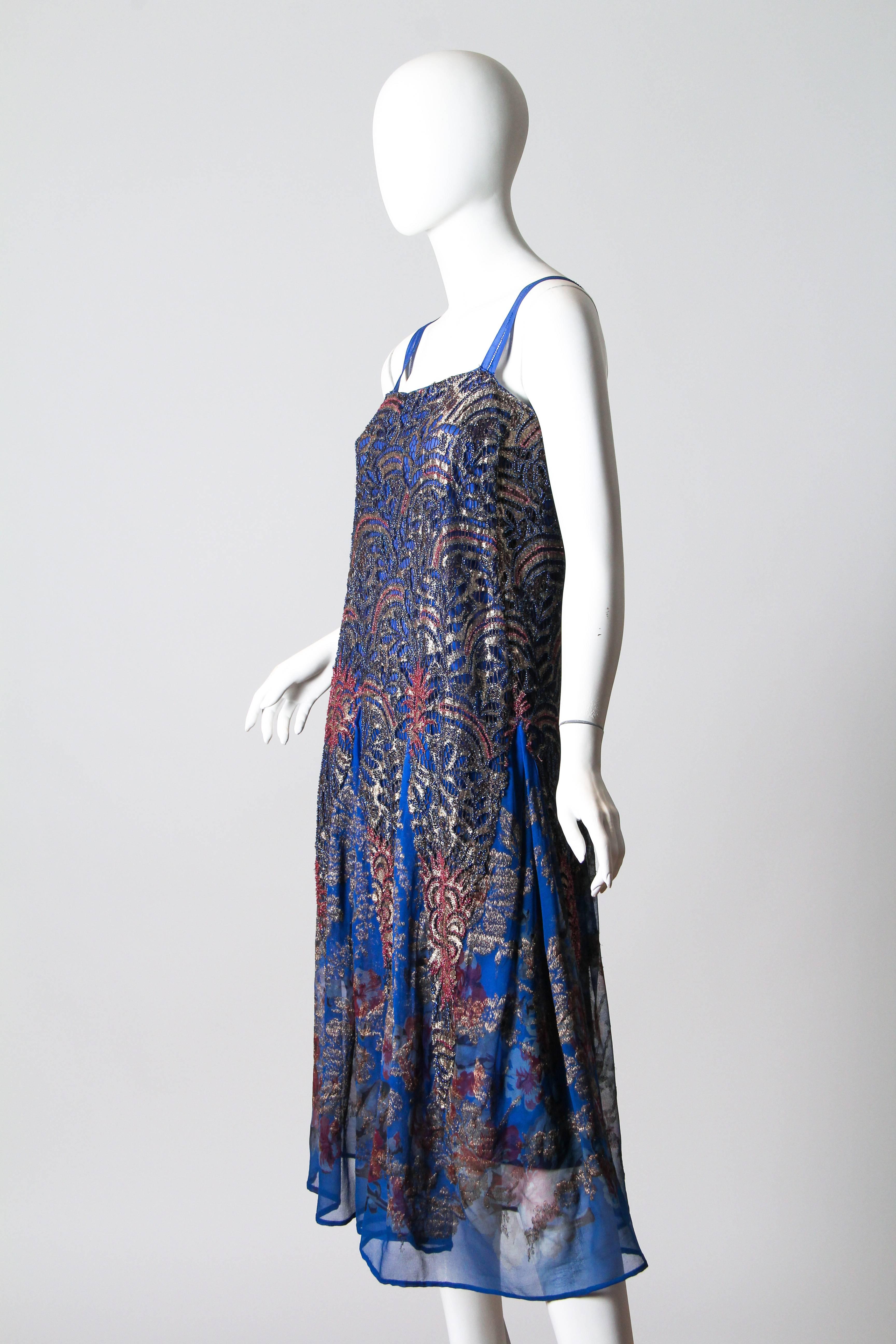 Very fine Art Deco lace in silver beaded to match the printed skirt also woven with silver. Dress is sewn to its original slip and has been restored to a very wearable condition.
