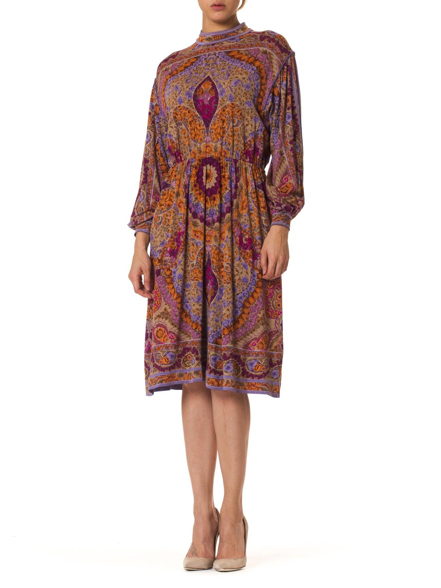 This is a wonderful paisley and floral dress in playful hues of orange and violet. The exuberant pattern is arranged thoughtfully and symetrically on the dress, with large motifs accenting the lines of the body underneath. By this means, the
