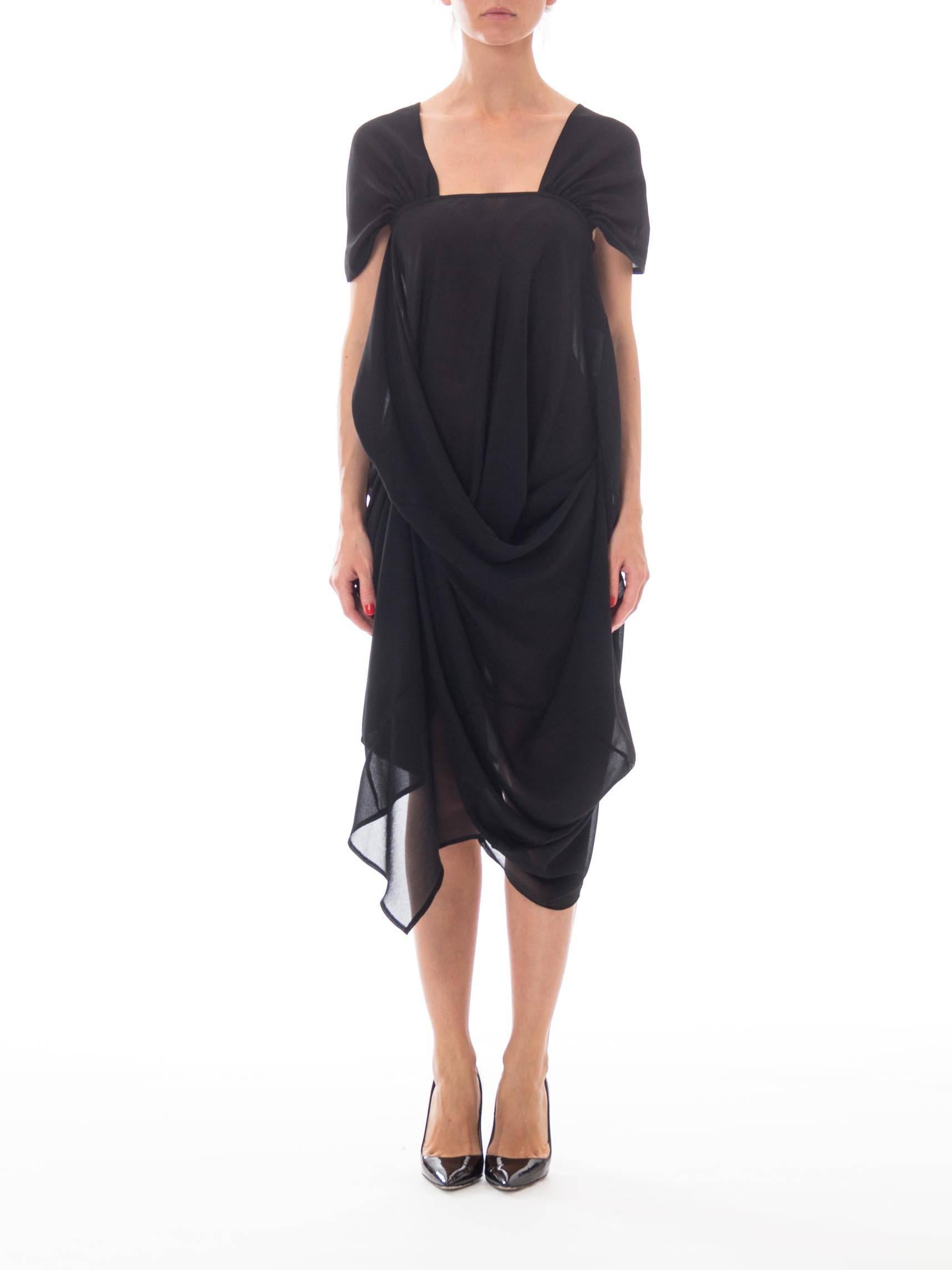 This is a stunning avant-garde dress by Junya Watanabe for Comme des Garçons. Marrying the easy styling of an LBD with the elegance of a classic evening gown, it is beautifully designed and skillfully made. The body of the dress is a shift of black