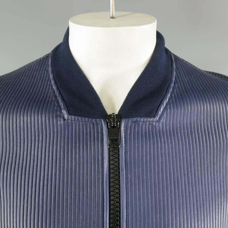 GUCCI Jacket consists of 100% leather material in a rich navy color tone. Designed with a textured leather appearance in a stripe/ribbed pattern throughout body and sleeve, zipper front in a black color tone and ribbed collar. 2-bottom zipper