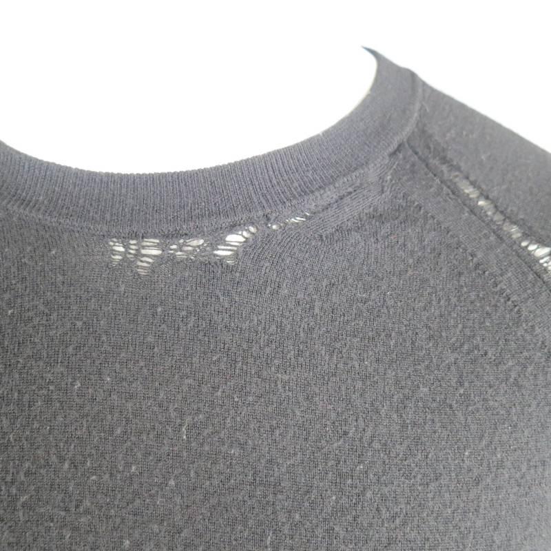 This rare DIOR HOMME by HEDI SLIMANE pull over sweater comes in a light weight, semi sheer black wool and features a crew neck with run distressing, raglan sleeves with runs distressed along the seam, an horizontal back seam details. This piece