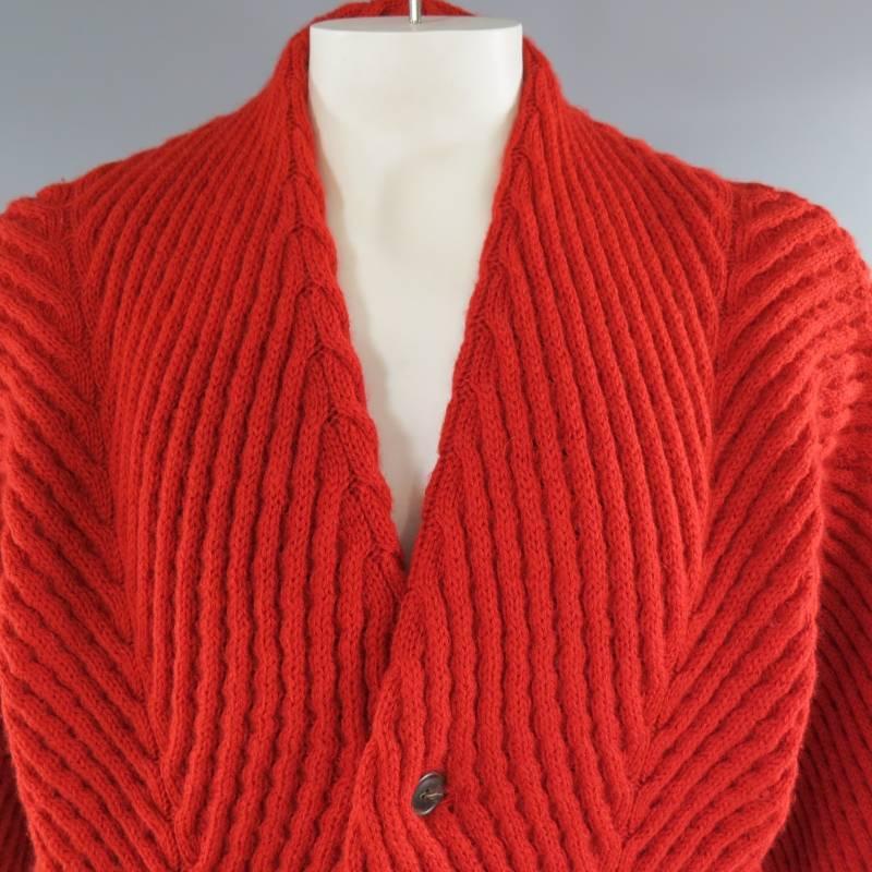 This rare vintage ISSEY MIYAKE cardigan comes in a thick directional ribbed red wool with cable knit details and features thick ribbed bands, tortoise buttons and drop shoulder batwing sleeves. Made in Japan.
 
Very Good Pre-Owned Vintage